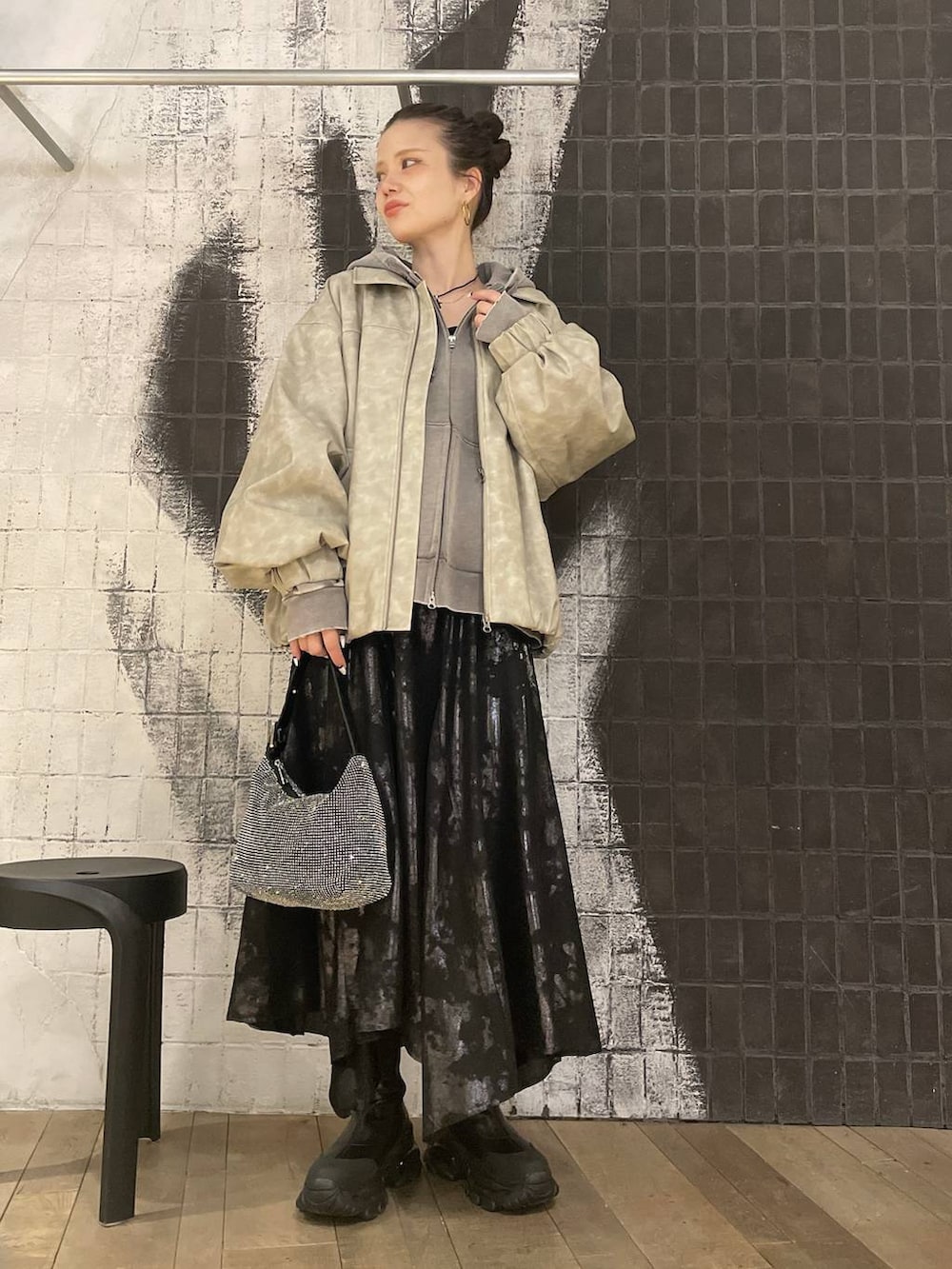 ベージュ系のブルゾン、グレー系のパーカー、ブラック系のブーツを着用したレディースの冬コーディネートの5枚目の写真