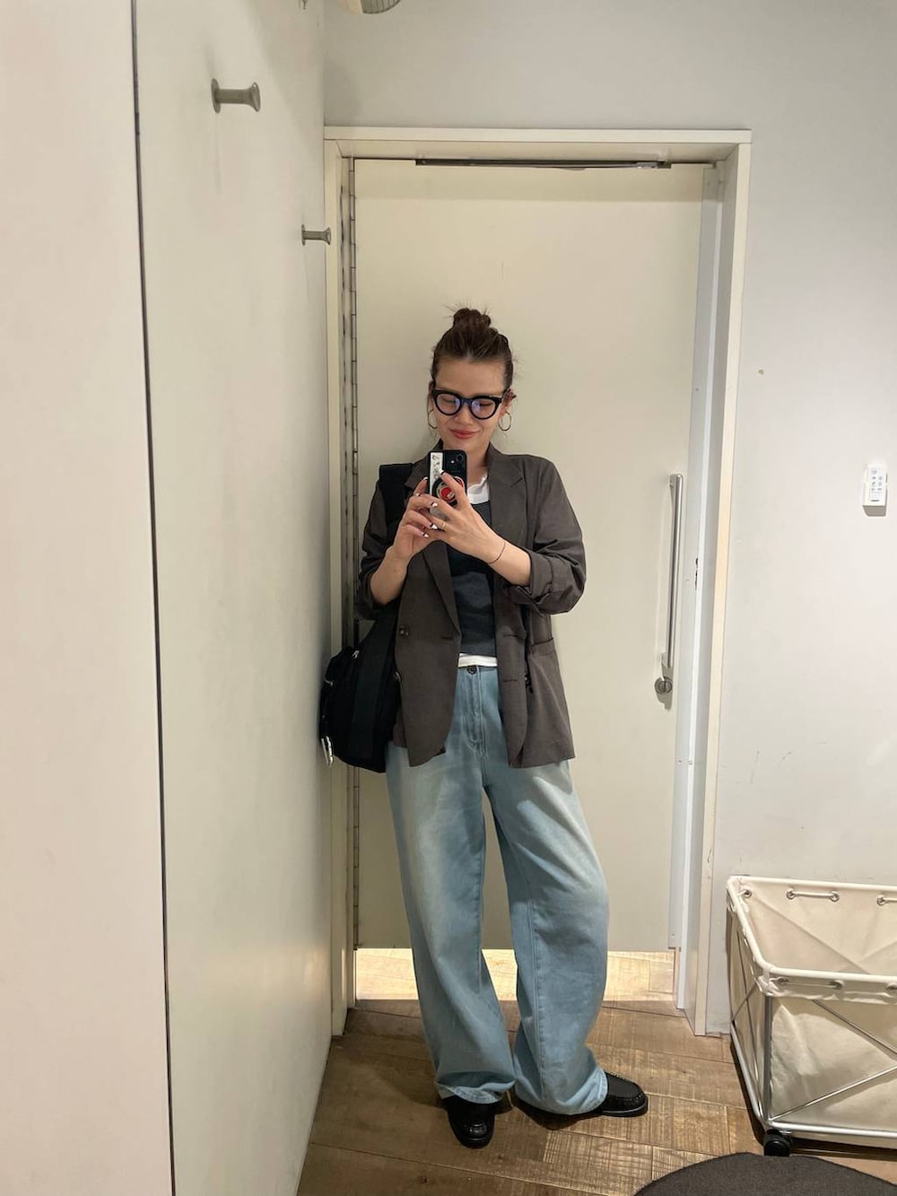 ブラック系のショルダーバッグ、ホワイト系のTシャツ/カットソー、ブラック系のローファーを着用したレディースの春コーディネートの7枚目の写真