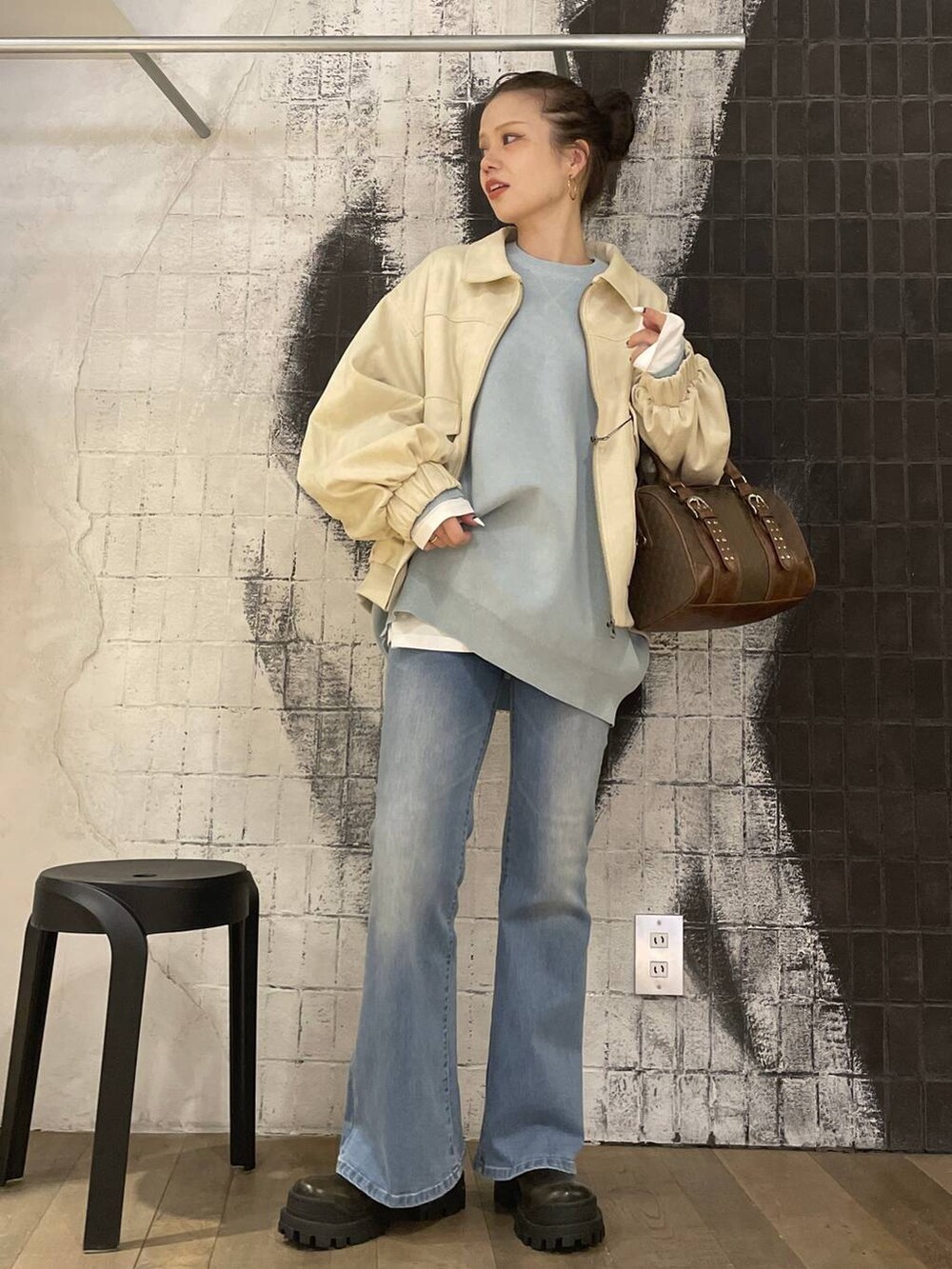 ブルー系のニット/セーター、ホワイト系のブルゾン、グリーン系のボストンバッグを着用したレディースの秋コーディネートの5枚目の写真