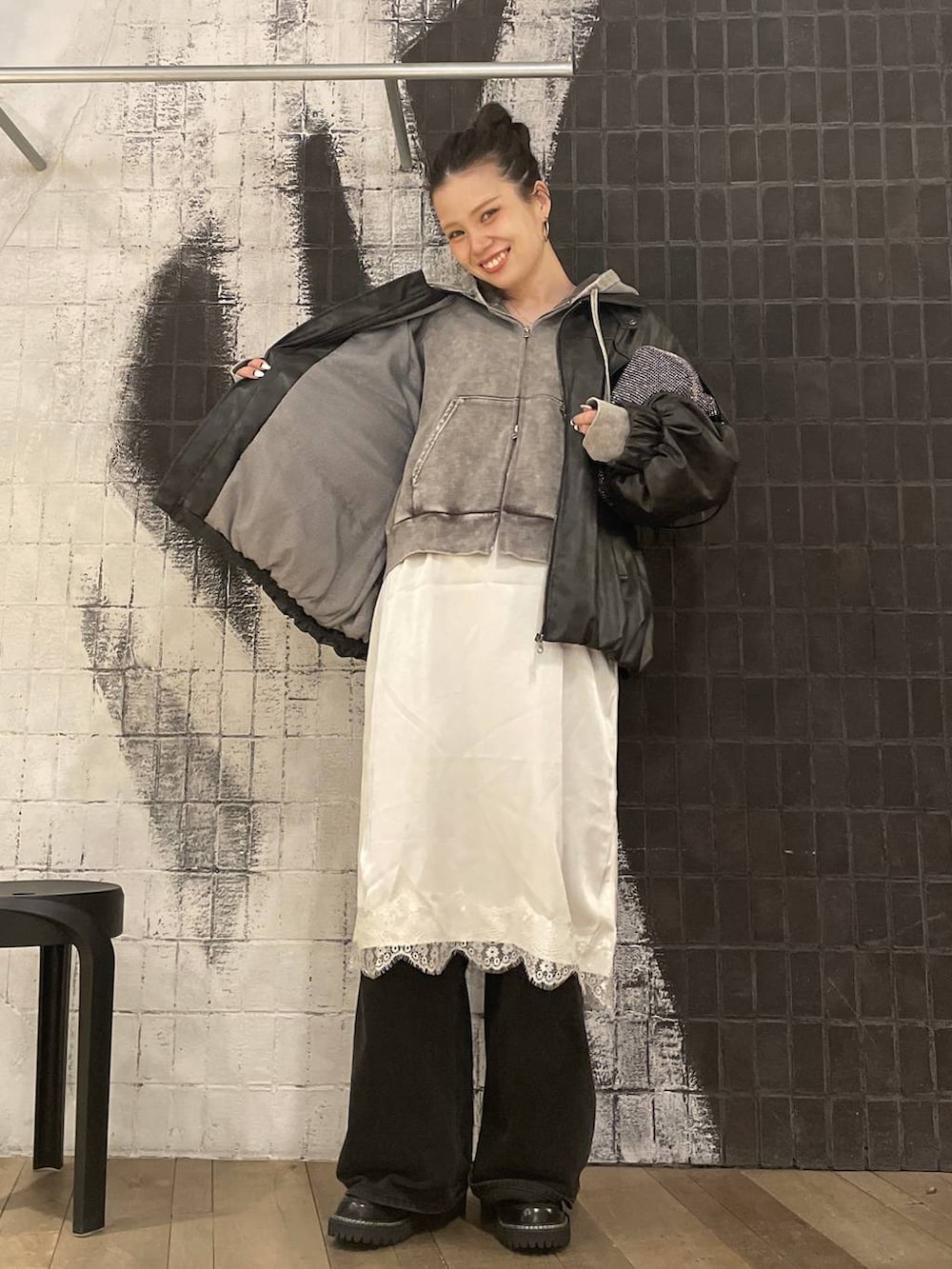 ブラック系のブルゾン、グレー系のパーカー、グレー系のデニムパンツを着用したレディースの冬コーディネートの4枚目の写真