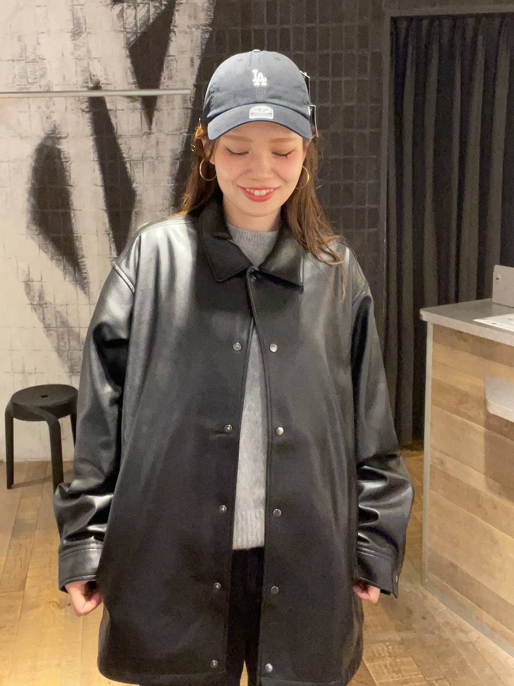 ブラック系のショルダーバッグ、グレー系のデニムパンツ、ブラック系のライダースジャケットを着用したレディースの秋コーディネートの4枚目の写真