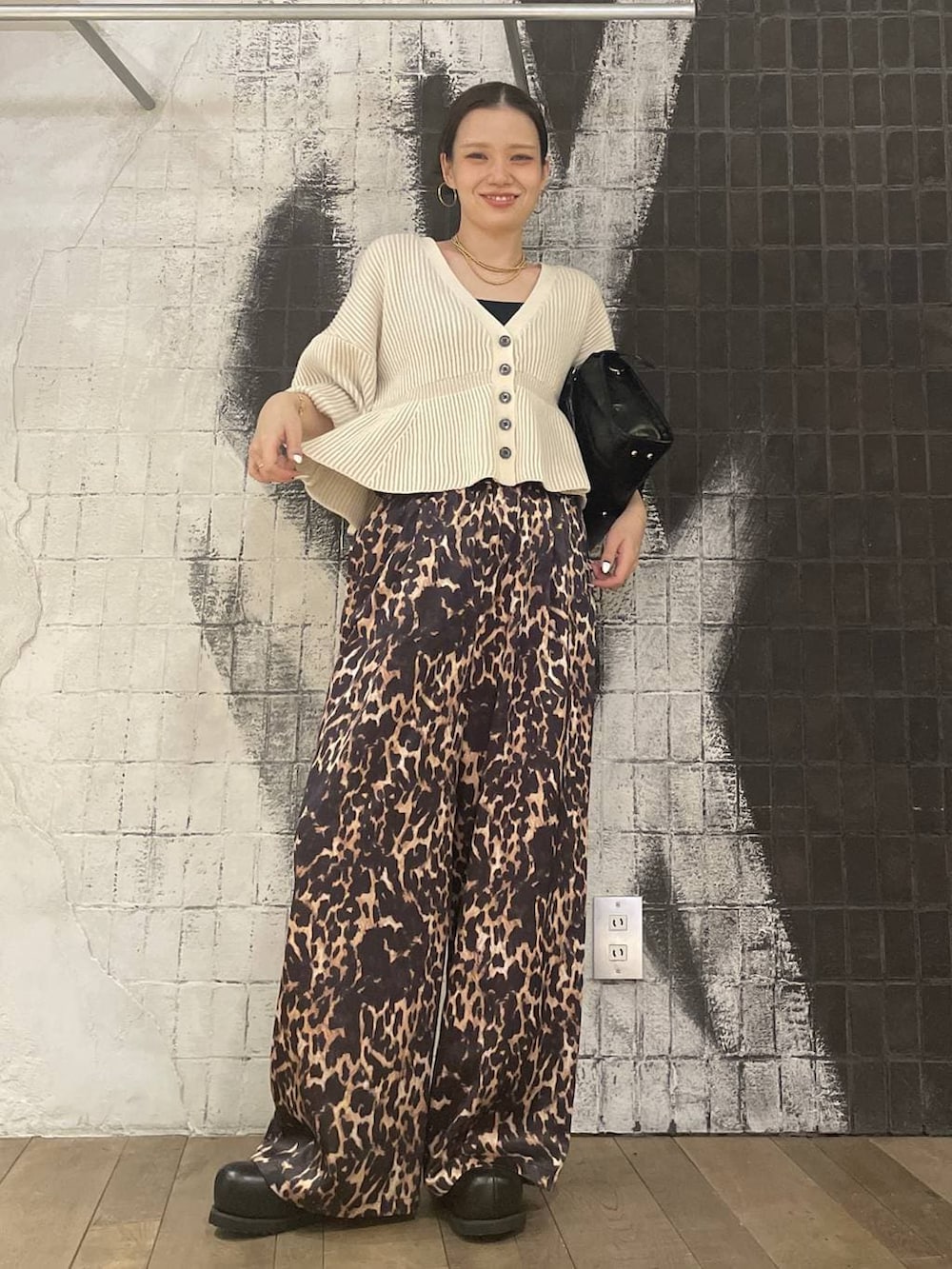 ブラック系のボストンバッグ、ブラウン系のその他シューズ、ホワイト系のカーディガン/ボレロを着用したレディースの冬コーディネートの5枚目の写真