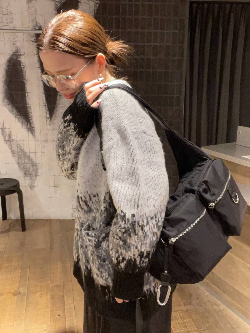 ブラック系のショルダーバッグ、ブラック系のブーツ、グレー系のカーディガン/ボレロを着用したレディースの冬コーディネートの7枚目の写真