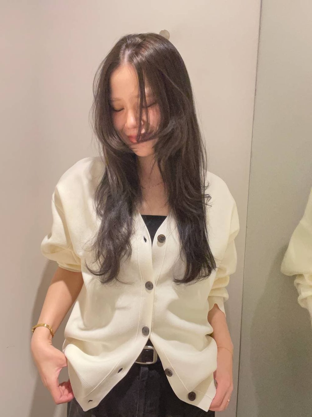 グレー系のデニムパンツ、ホワイト系のカーディガン/ボレロを着用したレディースの秋コーディネートの5枚目の写真