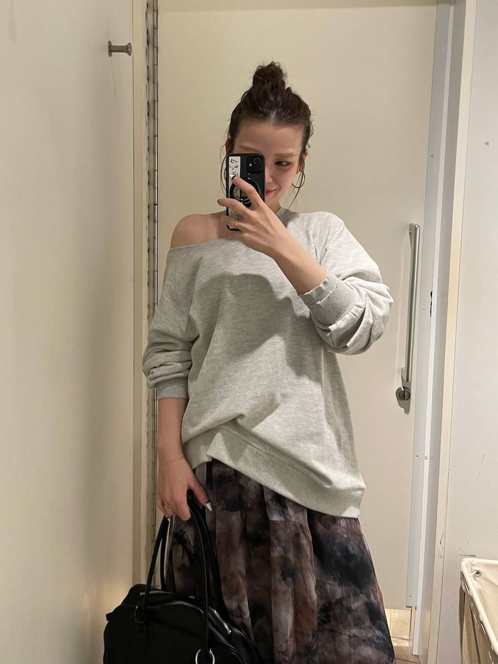 グレー系のスウェット、ブラック系のスカート、ブラック系のボストンバッグを着用したレディースの春コーディネートの5枚目の写真