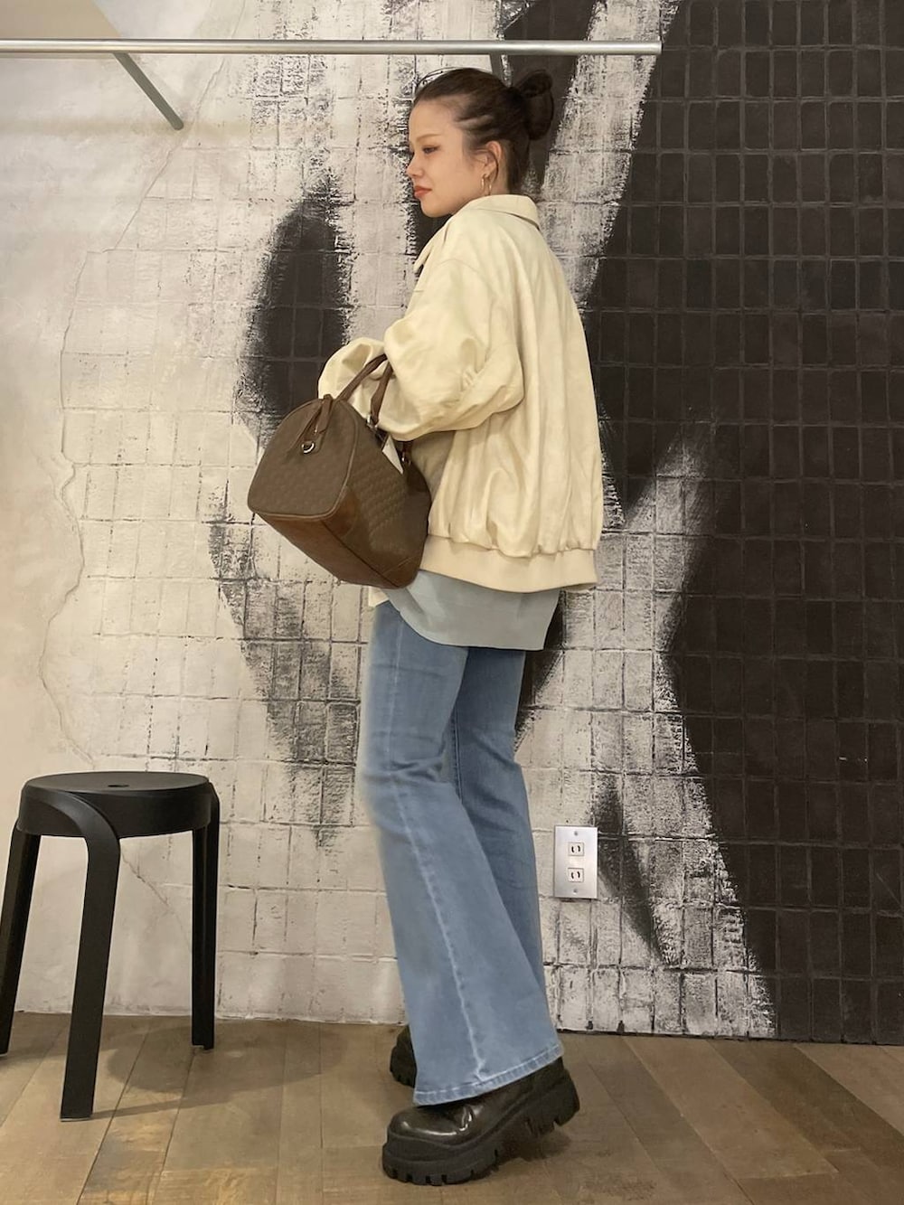 ブルー系のニット/セーター、ホワイト系のブルゾン、グリーン系のボストンバッグを着用したレディースの秋コーディネートの3枚目の写真