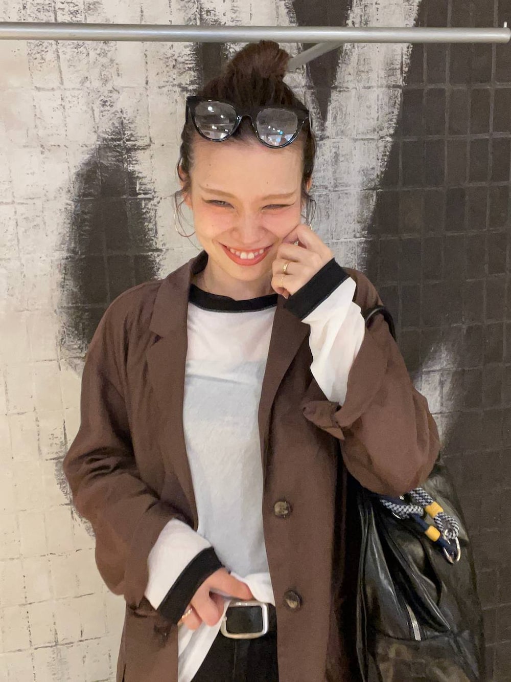 グレー系のデニムパンツ、ブラック系のボストンバッグ、ブラウン系のサンダルを着用したレディースの秋コーディネートの8枚目の写真