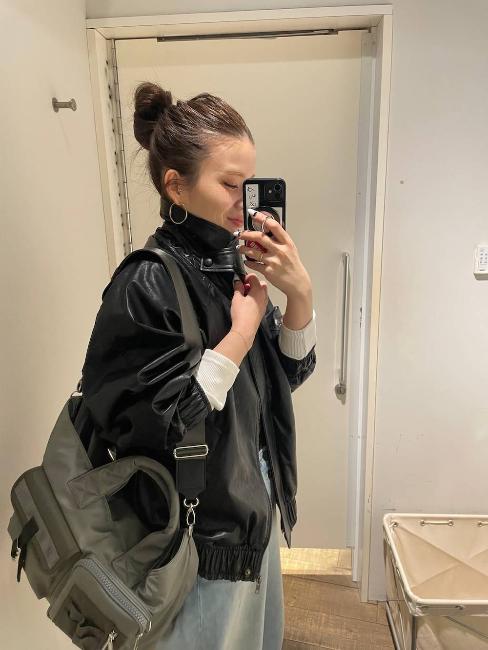 グリーン系のトートバッグ、ブルー系のデニムパンツ、ホワイト系のTシャツ/カットソーを着用したレディースの春コーディネートの3枚目の写真