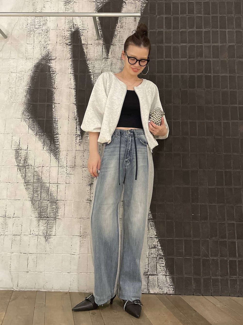 グレー系のスウェット、ブラック系のキャミソール、ブラック系のパンプスを着用したレディースの冬コーディネートの4枚目の写真