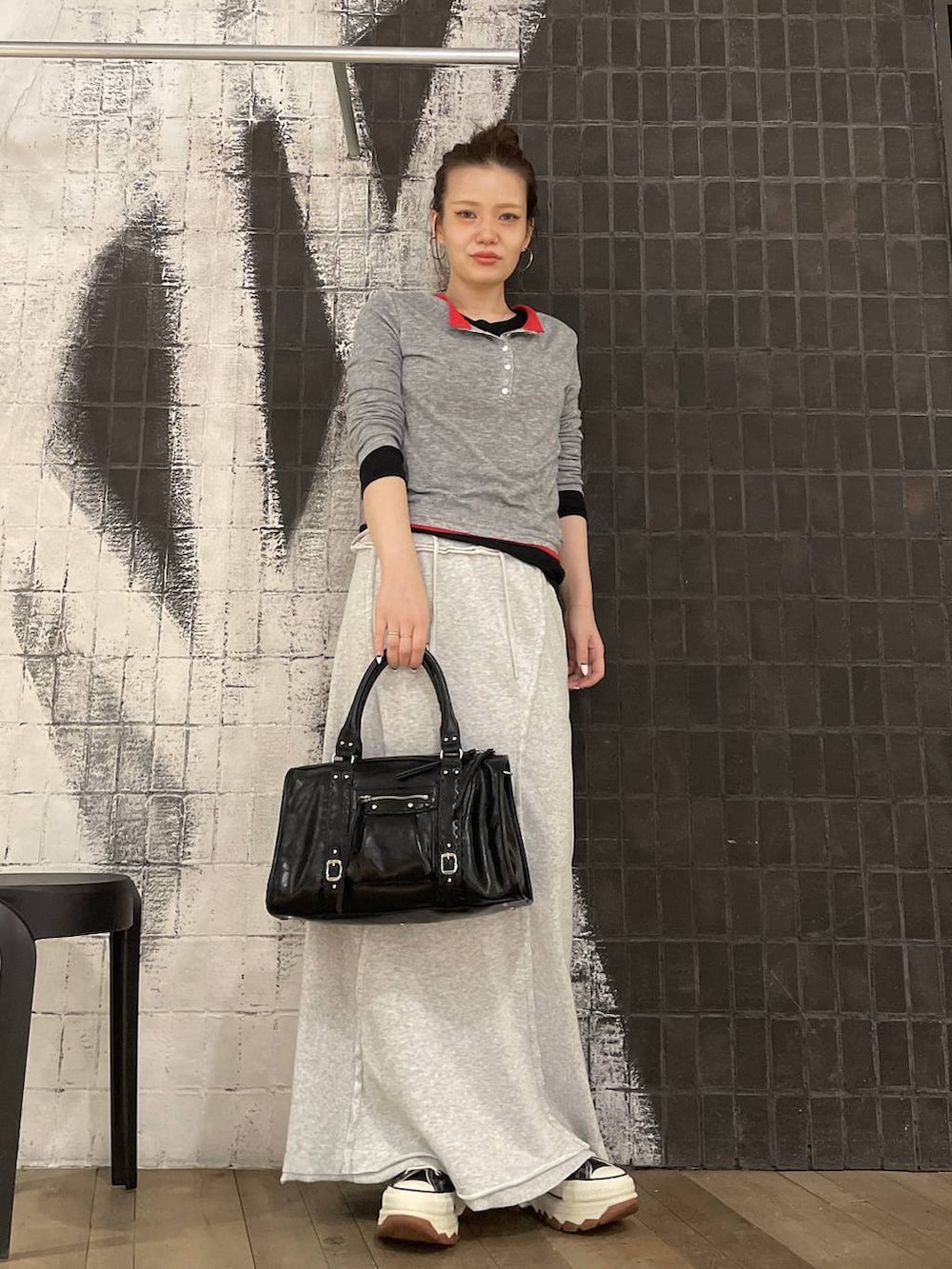 ブラック系のスニーカー、ブラック系のボストンバッグ、グレー系のスカートを着用したレディースの春コーディネートの6枚目の写真