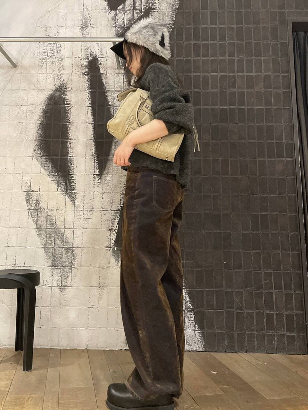 ベージュ系のボストンバッグ、ブラック系のその他シューズ、ブラウン系のデニムパンツを着用したレディースの冬コーディネートの4枚目の写真