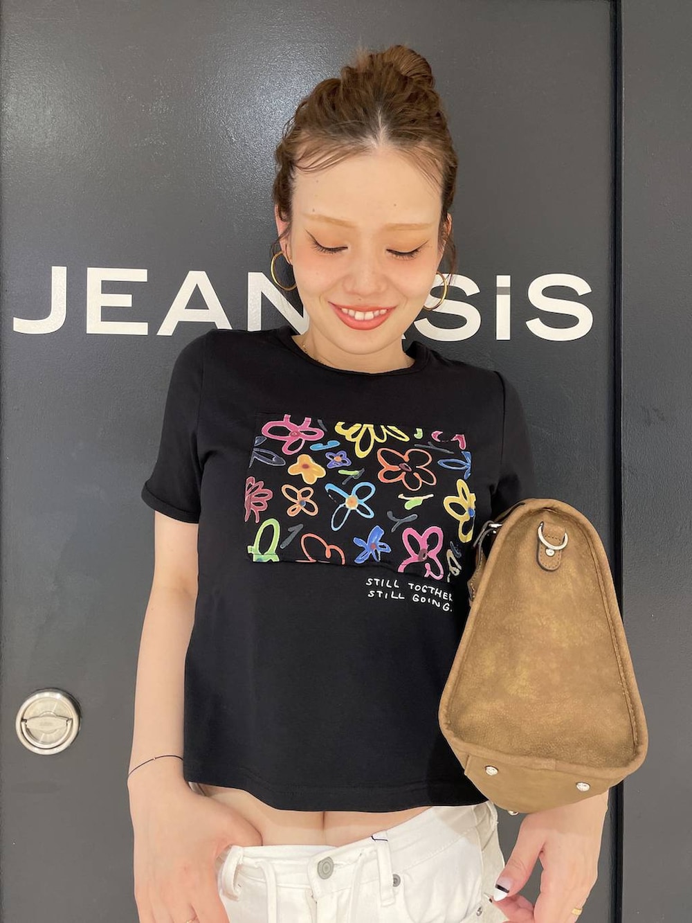 ブラック系のTシャツ/カットソー、ホワイト系のデニムパンツ、ブラウン系のボストンバッグを着用したレディースの夏コーディネートの6枚目の写真