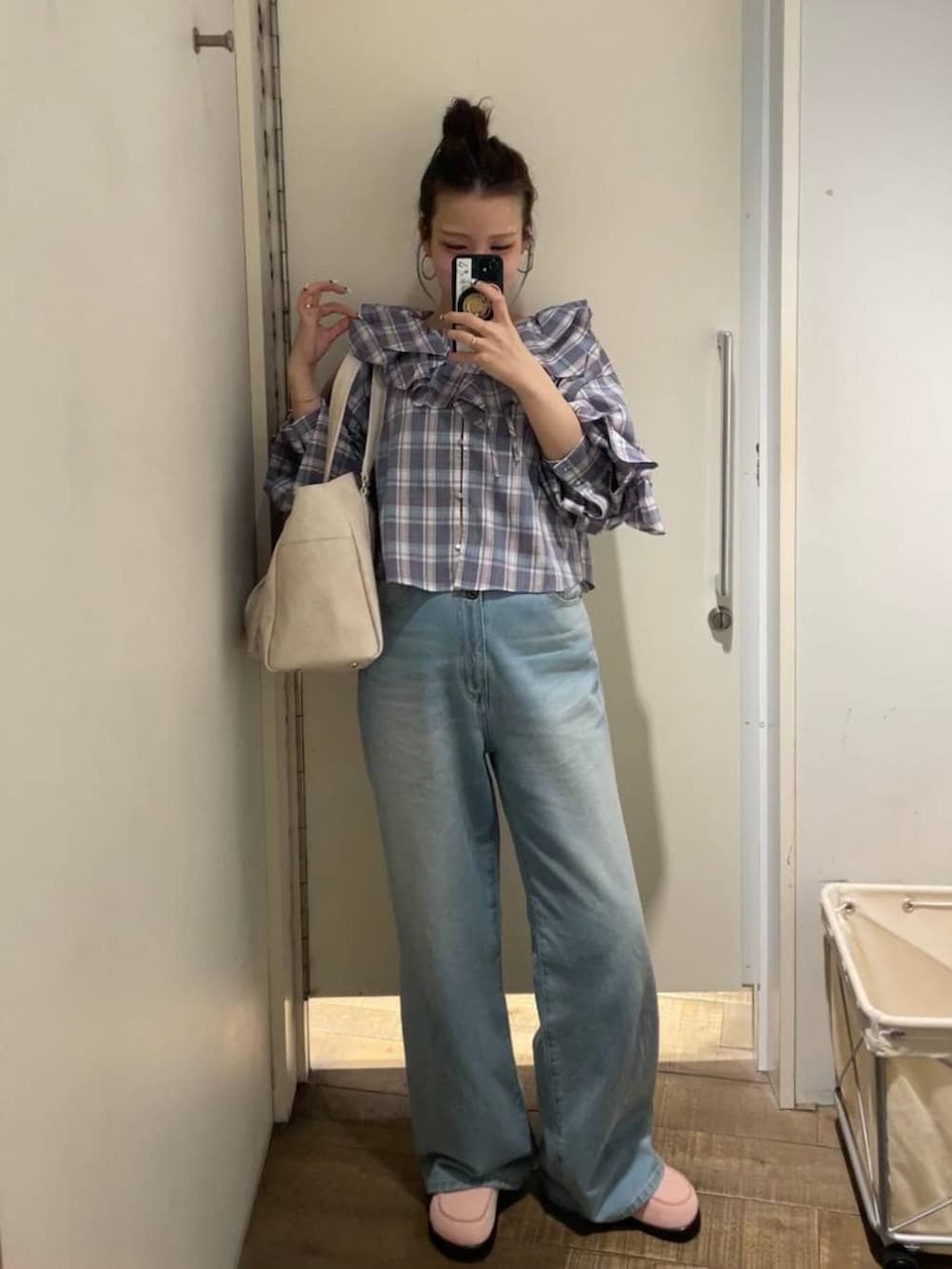 ピンク系のローファー、ホワイト系のトートバッグ、ブルー系のデニムパンツを着用したレディースの春コーディネートの2枚目の写真