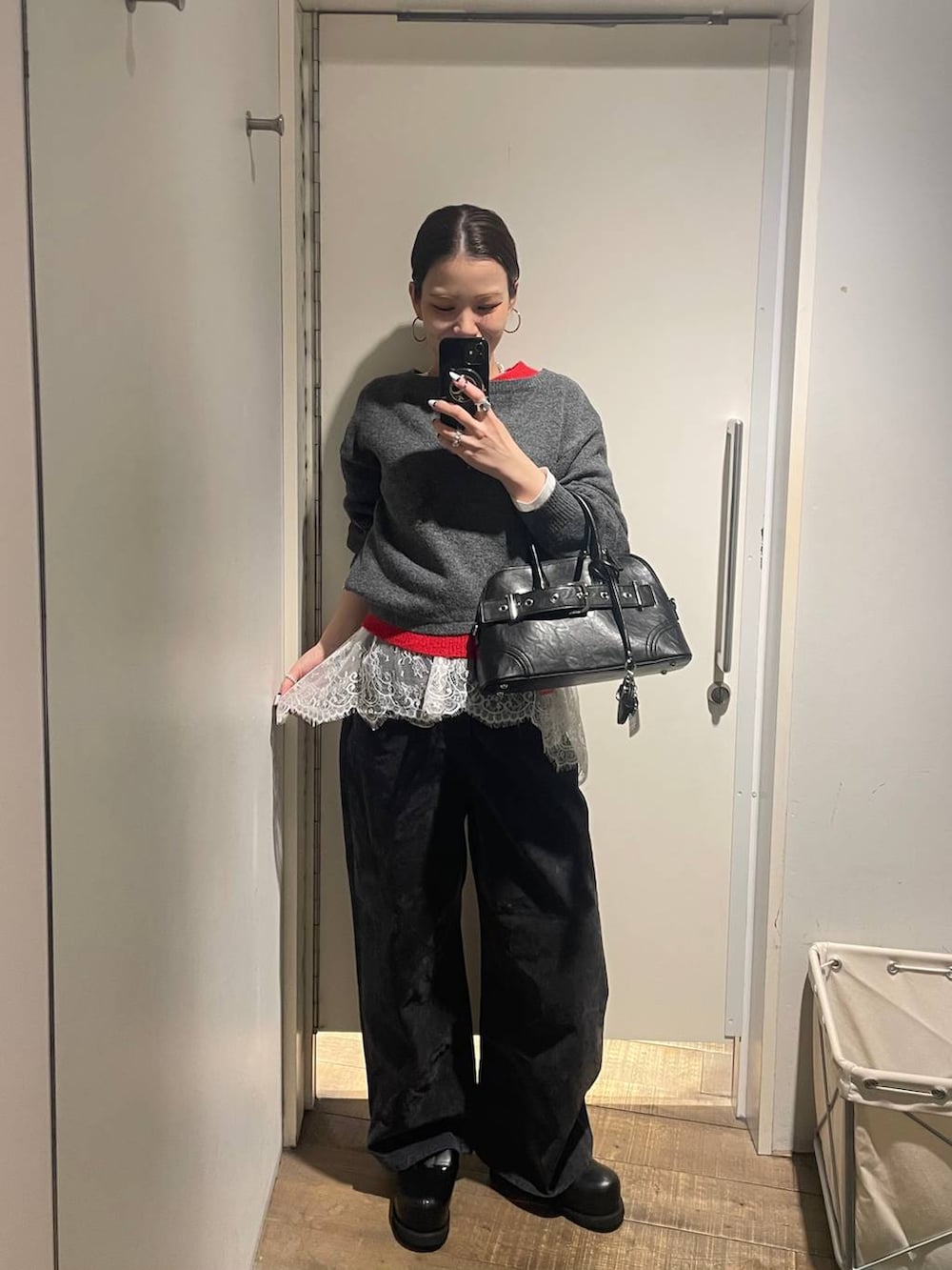 ブラック系のその他シューズ、ブラック系のボストンバッグ、ホワイト系のTシャツ/カットソーを着用したレディースの冬コーディネートの2枚目の写真