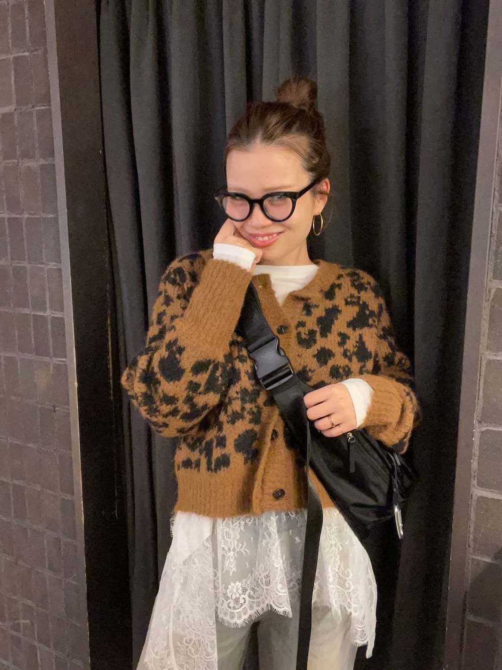 ブラック系のショルダーバッグ、ブルー系のデニムパンツ、ブラック系のブーツを着用したレディースの冬コーディネートの6枚目の写真