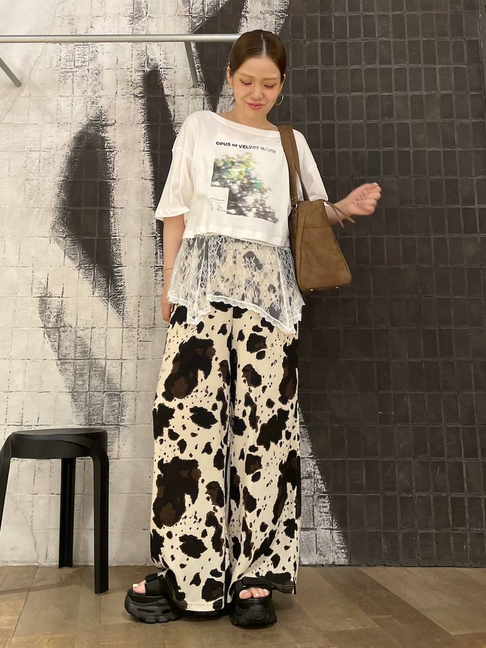 ベージュ系のその他パンツ、ブラウン系のトートバッグ、ブラック系のサンダルを着用したレディースの夏コーディネートの6枚目の写真