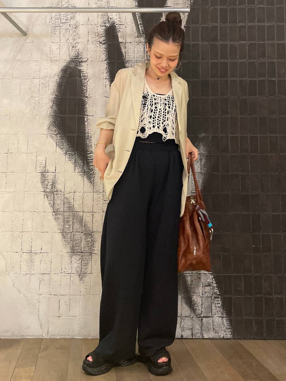 ホワイト系のベスト、ブラック系のサンダル、ブラウン系のボストンバッグを着用したレディースの夏コーディネートの8枚目の写真