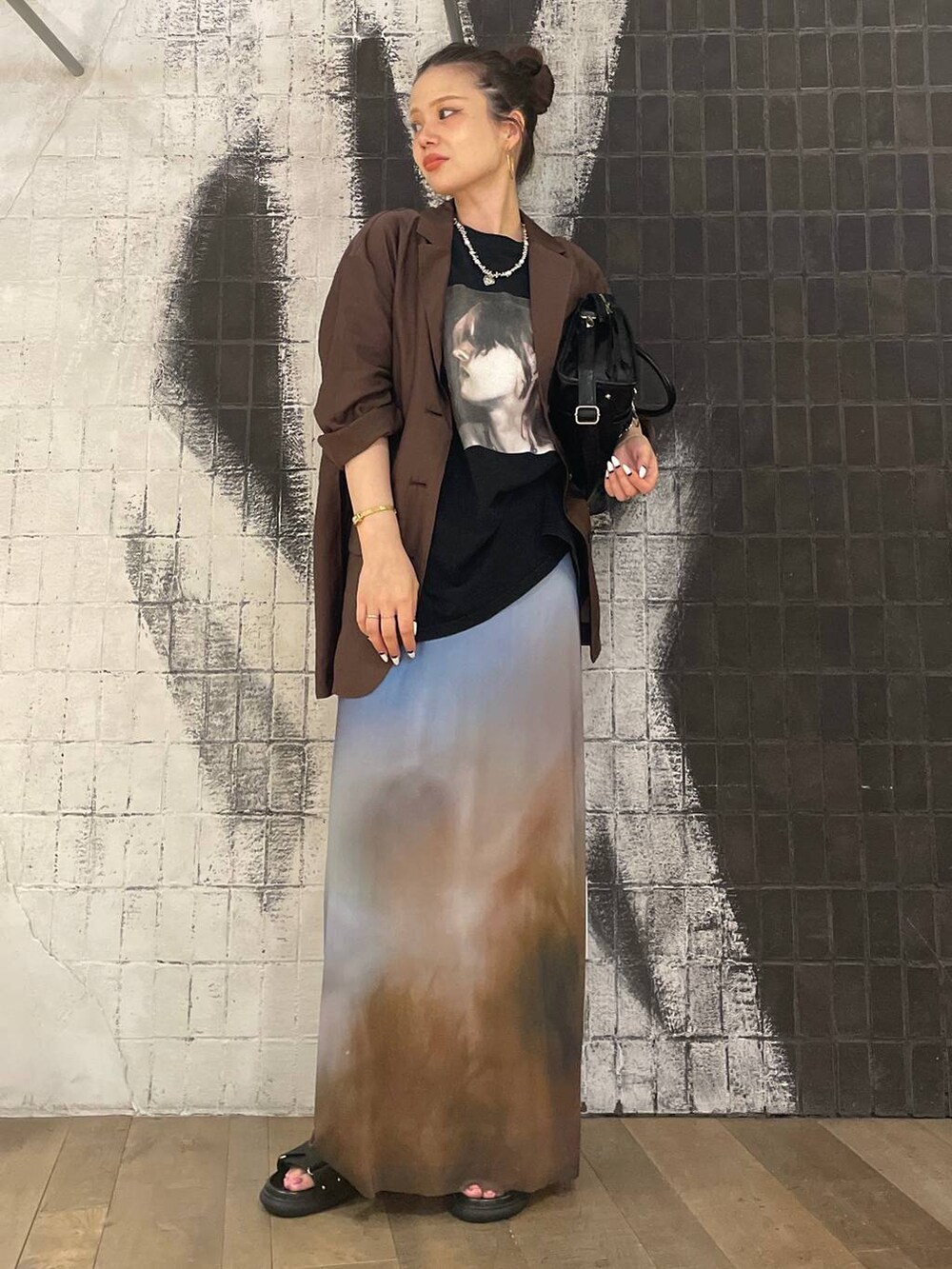 ブラック系のボストンバッグ、ブラック系のサンダル、ブラウン系のテーラードジャケットを着用したレディースの夏コーディネートの6枚目の写真