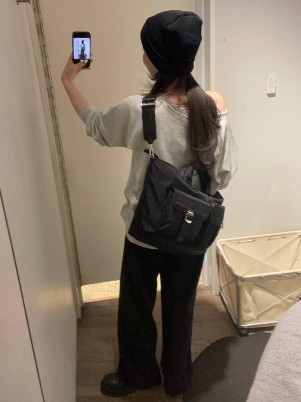 グレー系のスウェット、ブラック系のトートバッグ、ブラック系のデニムパンツを着用したレディースの冬コーディネートの7枚目の写真