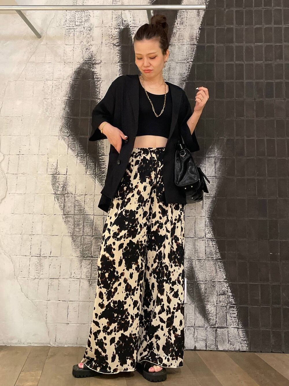 ブラック系のタンクトップ、ブラック系のボストンバッグ、ブラック系のサンダルを着用したレディースの夏コーディネートの4枚目の写真