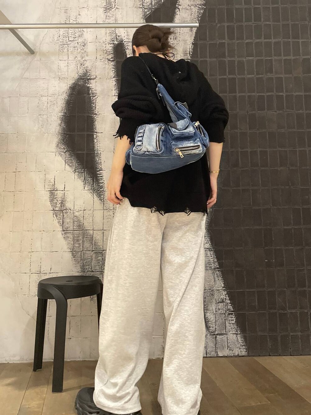 ブルー系のショルダーバッグ、ブラック系のブーツ、グレー系のスウェットパンツを着用したレディースの秋コーディネートの4枚目の写真