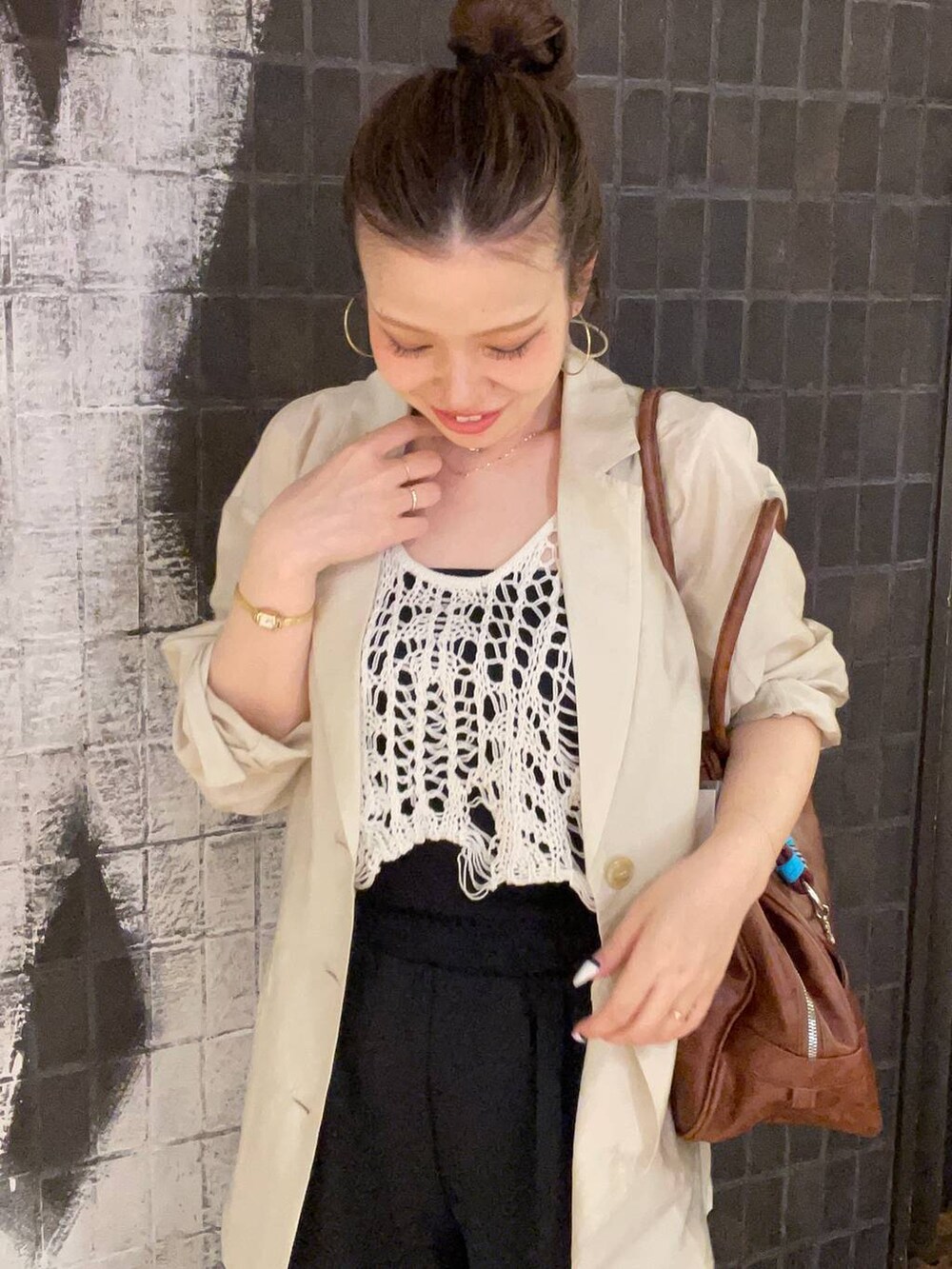 ホワイト系のベスト、ブラック系のサンダル、ブラウン系のボストンバッグを着用したレディースの夏コーディネートの5枚目の写真