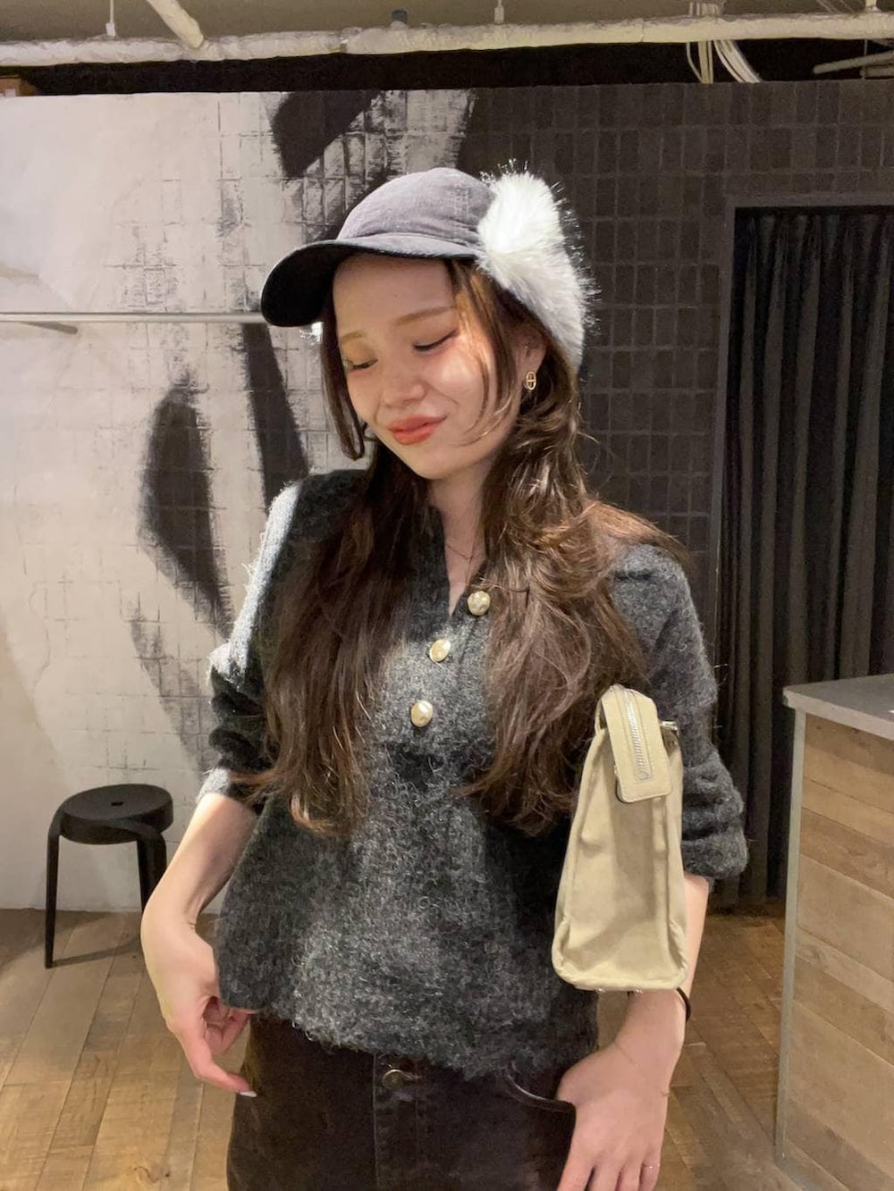 ベージュ系のボストンバッグ、ブラック系のその他シューズ、ブラウン系のデニムパンツを着用したレディースの冬コーディネートの3枚目の写真