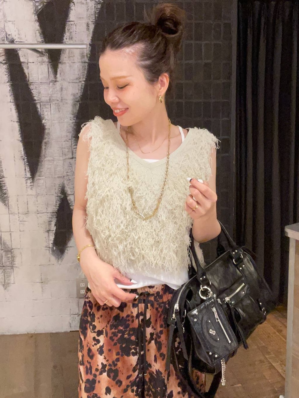 ブラック系のボストンバッグ、ホワイト系のタンクトップ、ブラック系のサンダルを着用したレディースの夏コーディネートの3枚目の写真