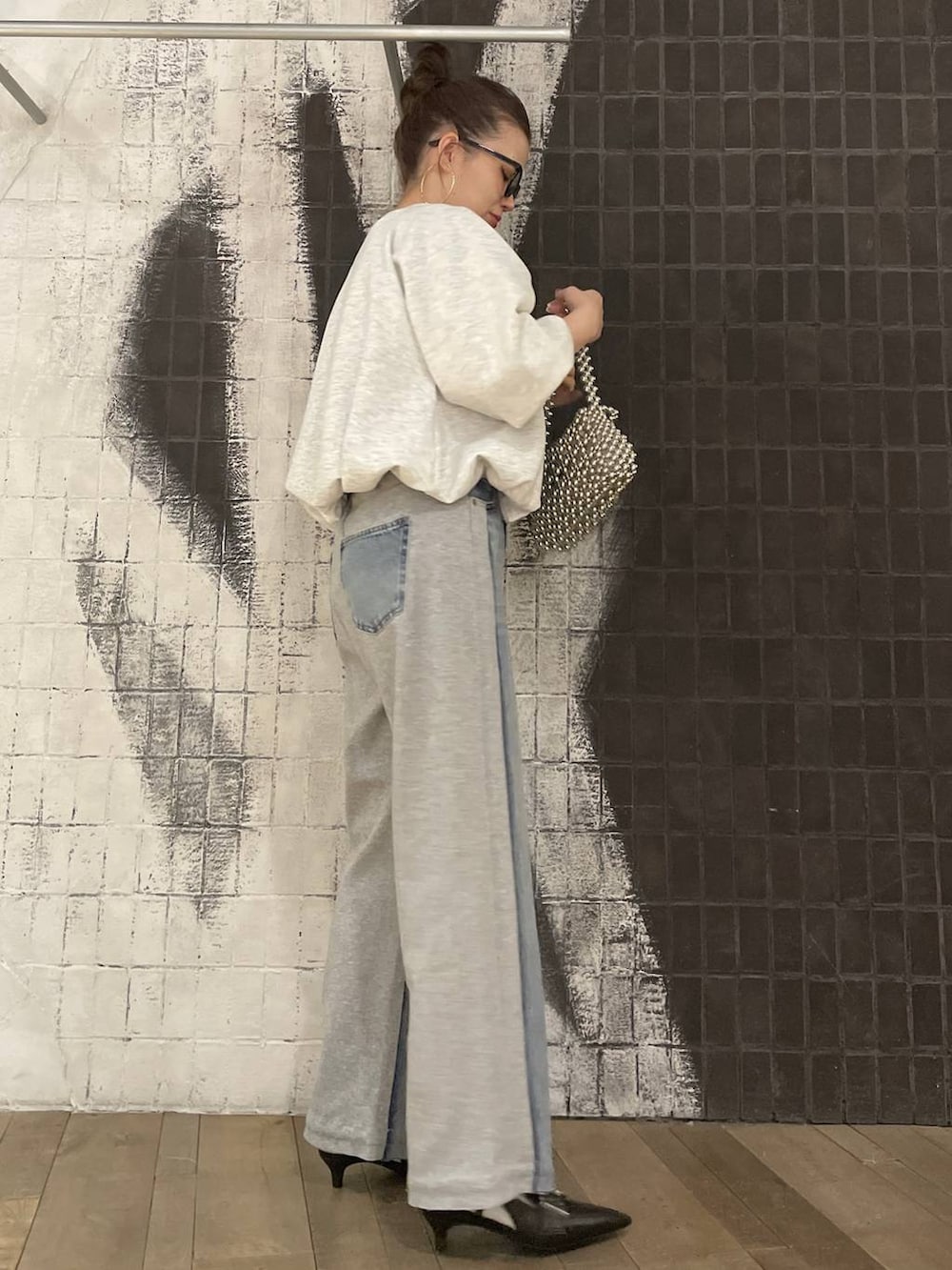 グレー系のスウェット、ブラック系のキャミソール、ブラック系のパンプスを着用したレディースの冬コーディネートの3枚目の写真