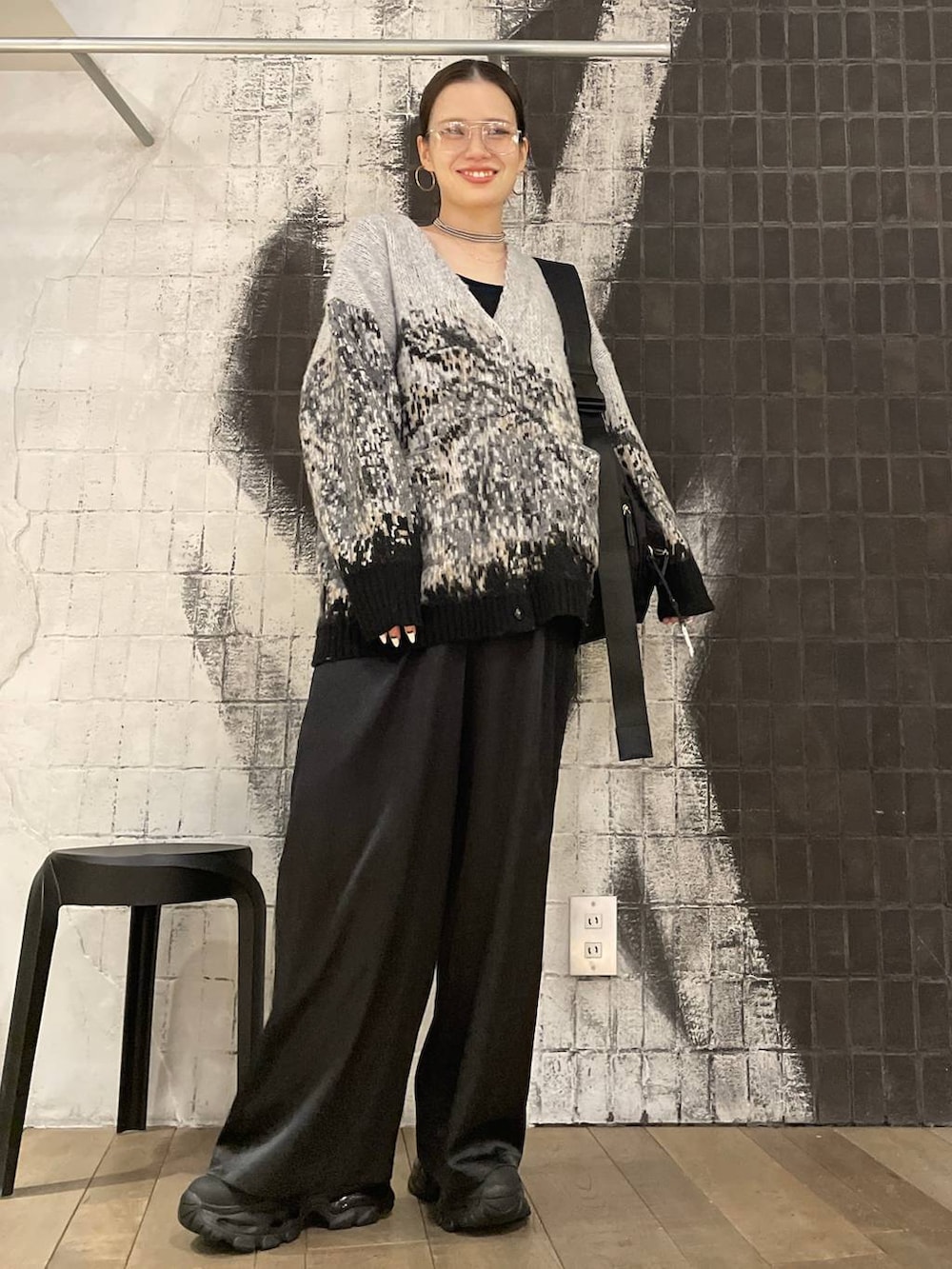 ブラック系のショルダーバッグ、ブラック系のブーツ、グレー系のカーディガン/ボレロを着用したレディースの冬コーディネートの2枚目の写真