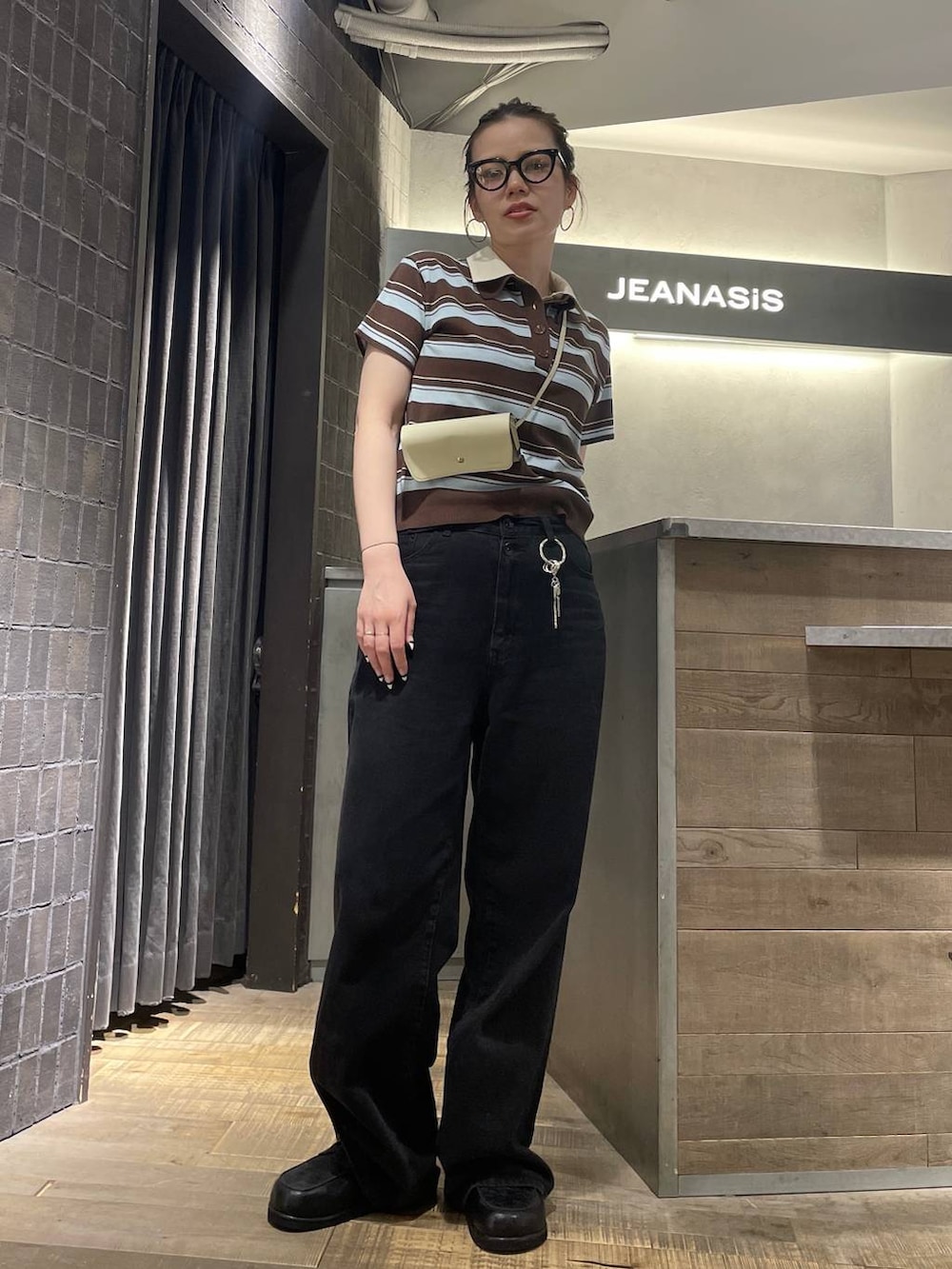 ブラック系のローファー、ブラック系のデニムパンツ、ブラウン系のポロシャツを着用したレディースの春コーディネートの7枚目の写真