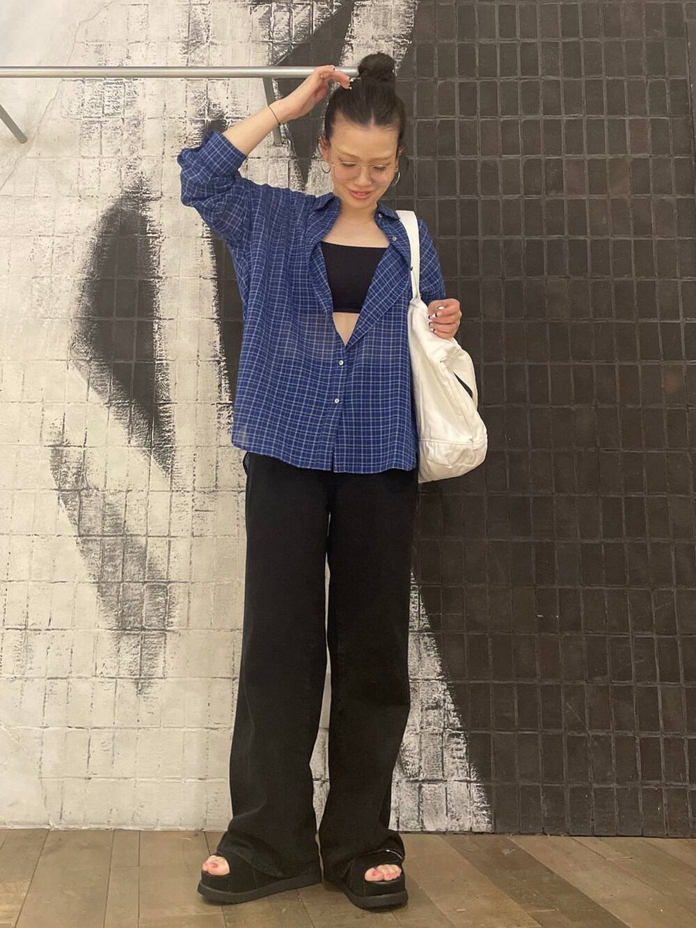 ブラック系のデニムパンツ、ブラック系のサンダル、ブルー系のシャツ/ブラウスを着用したレディースの春コーディネートの3枚目の写真