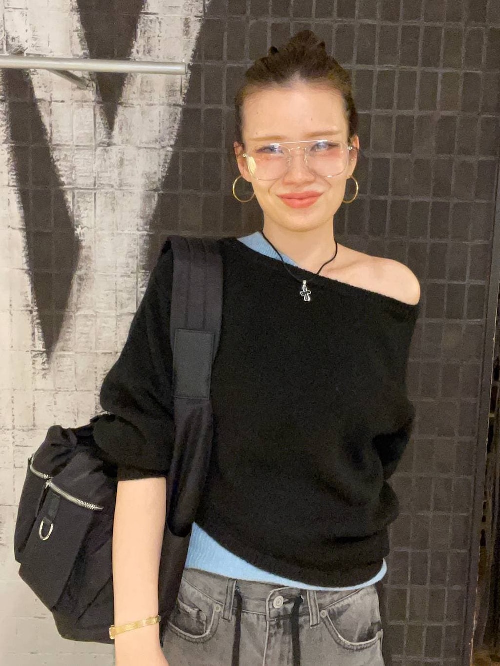 ブラック系のショルダーバッグ、ブラック系のデニムパンツ、ブラック系のブーツを着用したレディースの冬コーディネートの2枚目の写真