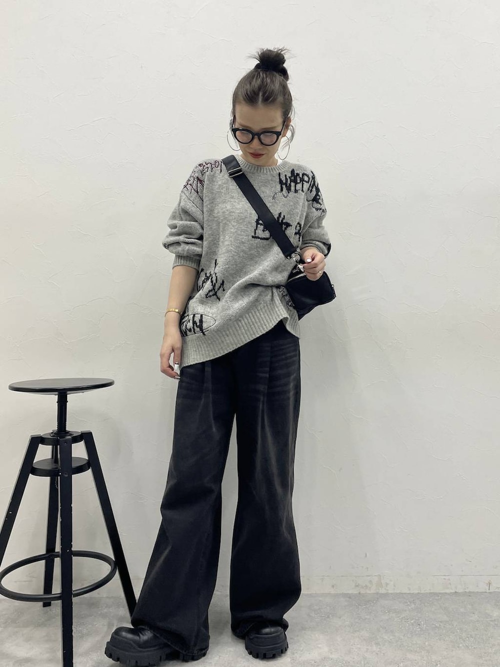 グレー系のデニムパンツ、ブラック系のブーツ、ブラック系のボストンバッグを着用したレディースの冬コーディネートの2枚目の写真