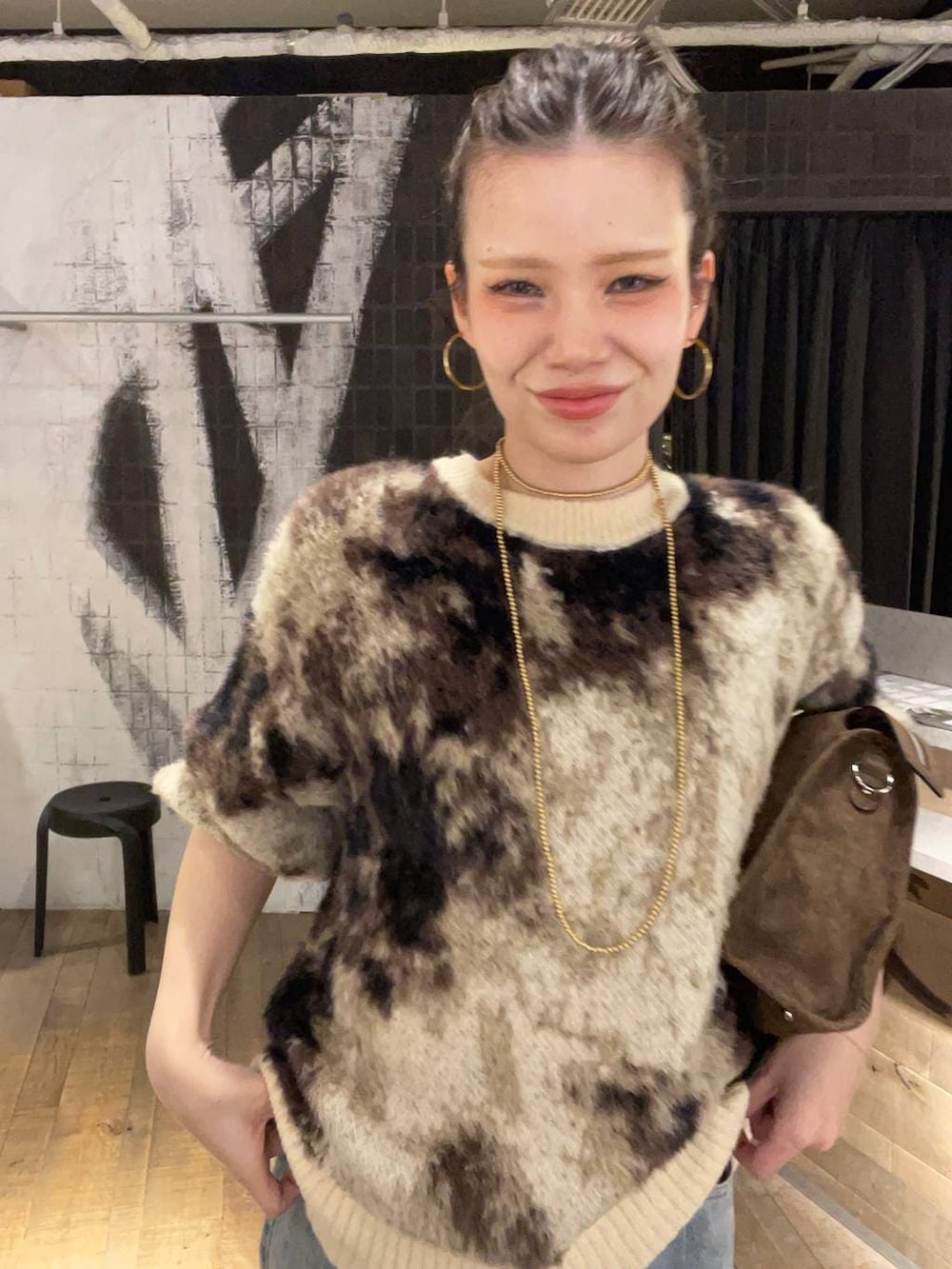 ブラウン系のニット/セーター、ブルー系のデニムパンツ、ブラウン系のボストンバッグを着用したレディースの冬コーディネートの3枚目の写真