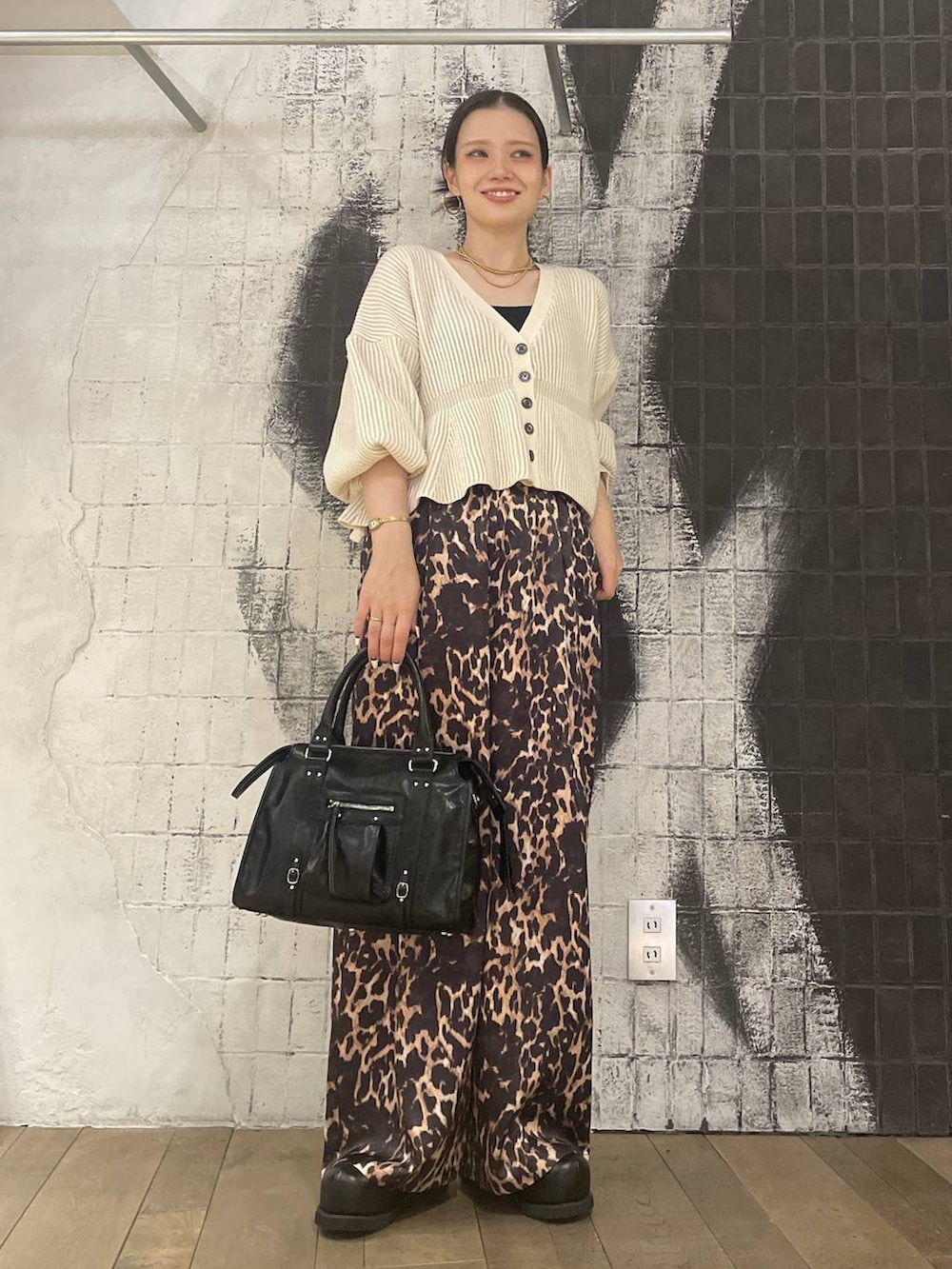 ブラック系のボストンバッグ、ブラウン系のその他シューズ、ホワイト系のカーディガン/ボレロを着用したレディースの冬コーディネートの3枚目の写真