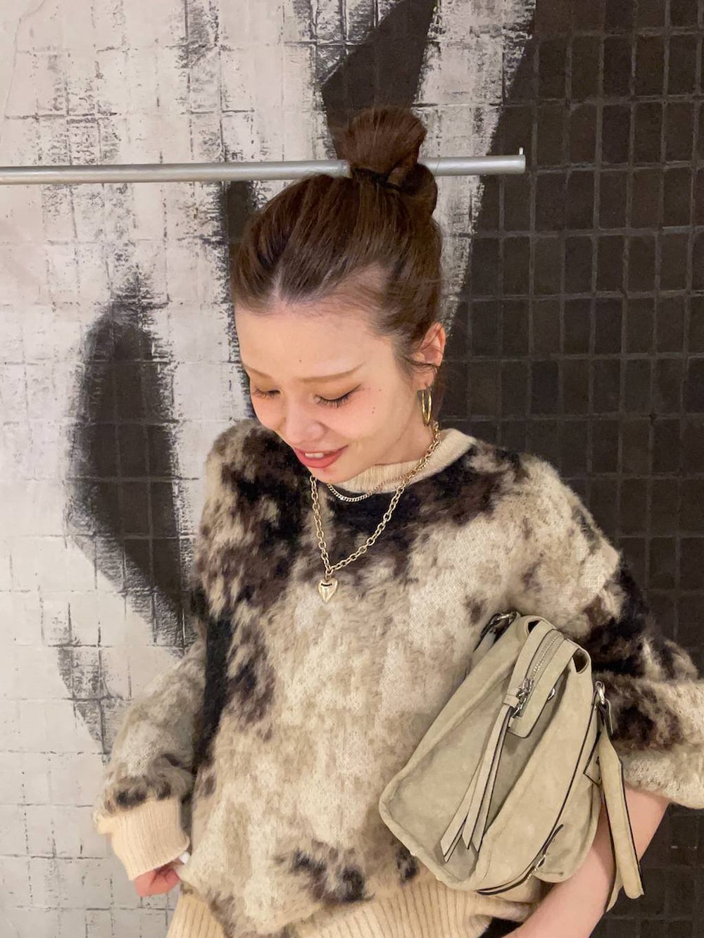 ブラウン系のニット/セーター、ベージュ系のボストンバッグ、ブラック系のブーツを着用したレディースの秋コーディネートの5枚目の写真