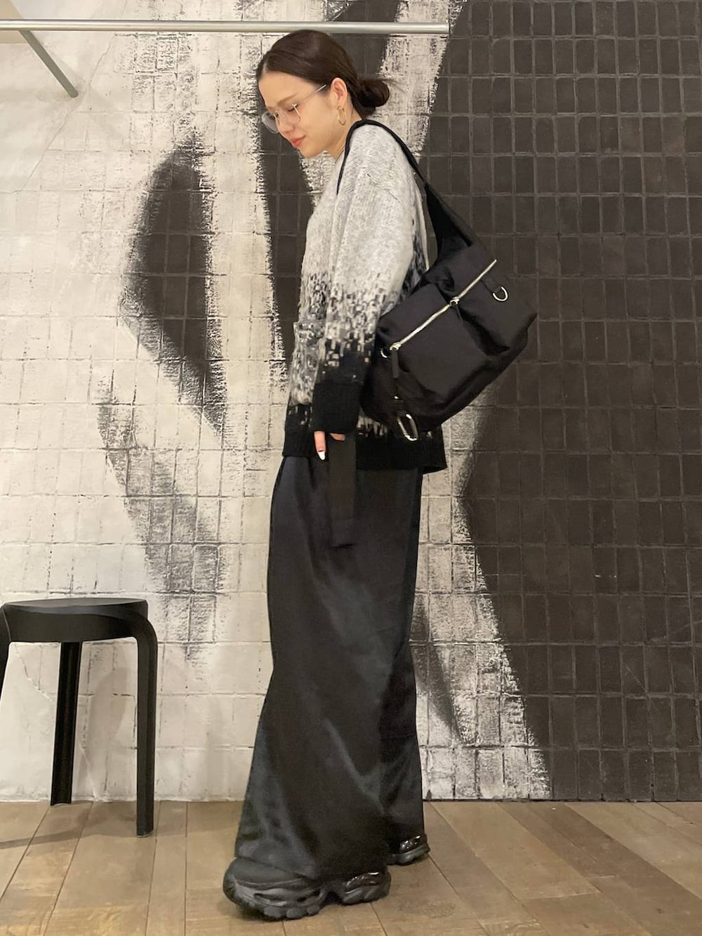 ブラック系のショルダーバッグ、ブラック系のブーツ、グレー系のカーディガン/ボレロを着用したレディースの冬コーディネートの6枚目の写真