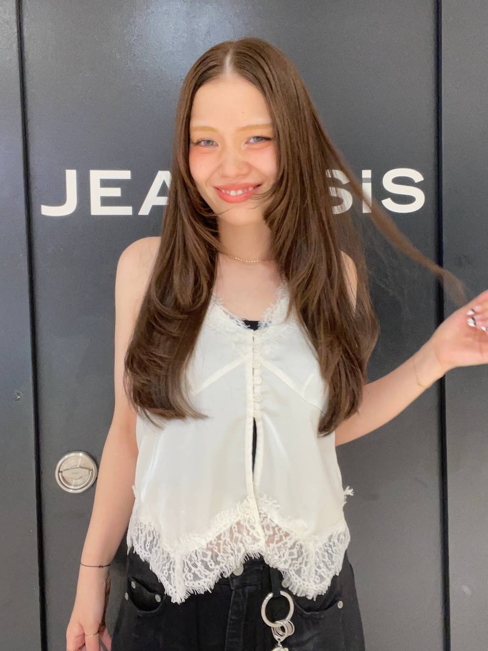 ブラック系のデニムパンツ、ホワイト系のベスト、ブラック系のベルトを着用したレディースの夏コーディネートの6枚目の写真