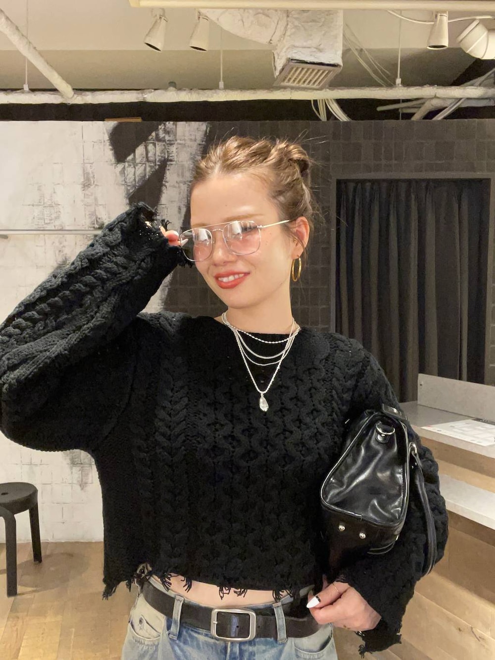 ブルー系のデニムパンツ、ブラック系のボストンバッグ、ブラック系のローファーを着用したレディースの秋コーディネートの3枚目の写真