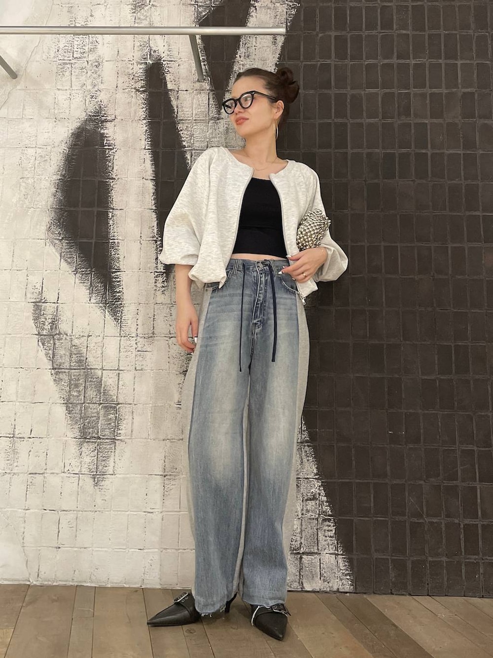 グレー系のスウェット、ブラック系のキャミソール、ブラック系のパンプスを着用したレディースの冬コーディネートの2枚目の写真