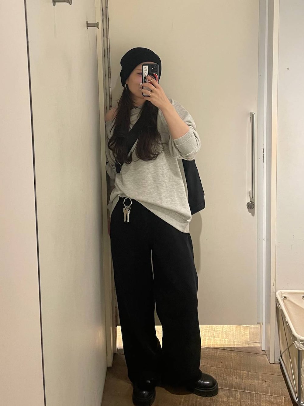 グレー系のスウェット、ブラック系のトートバッグ、ブラック系のデニムパンツを着用したレディースの冬コーディネートの8枚目の写真