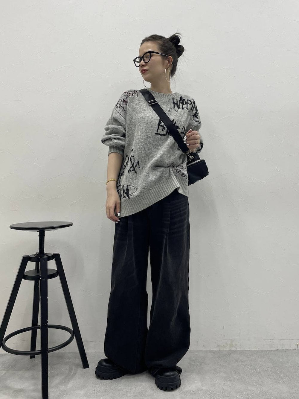 グレー系のデニムパンツ、ブラック系のブーツ、ブラック系のボストンバッグを着用したレディースの冬コーディネートの4枚目の写真