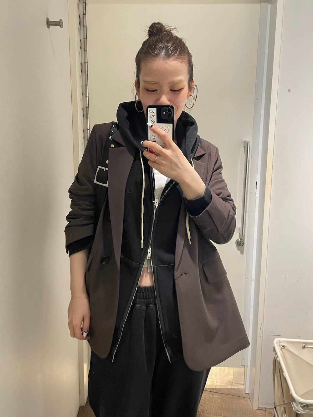 ブラック系のパーカー、ブラック系のスウェットパンツ、ホワイト系のキャミソールを着用したレディースの冬コーディネートの7枚目の写真