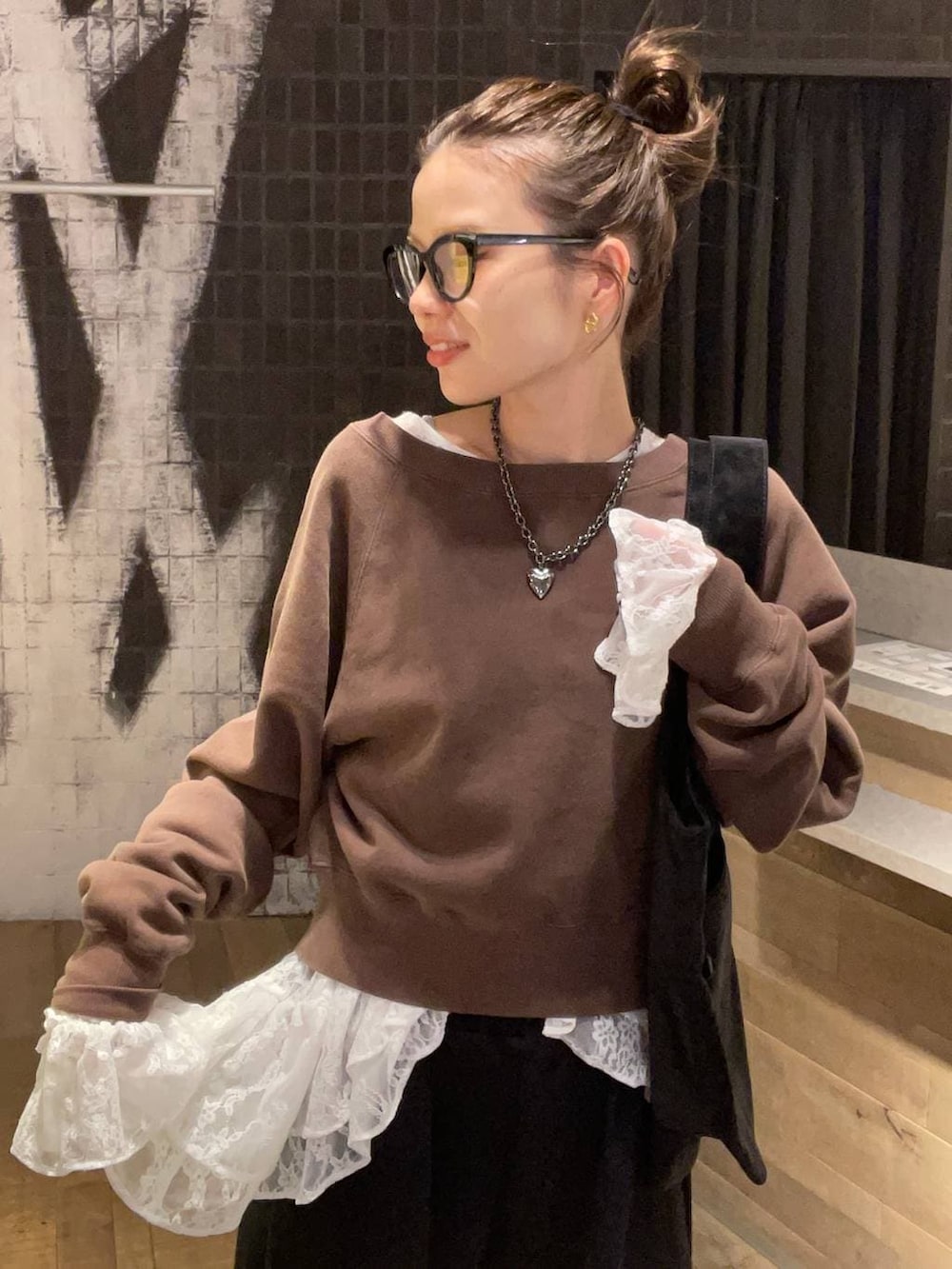 ブラック系のローファー、ブラウン系のスウェット、ブラック系のトートバッグを着用したレディースの冬コーディネートの3枚目の写真