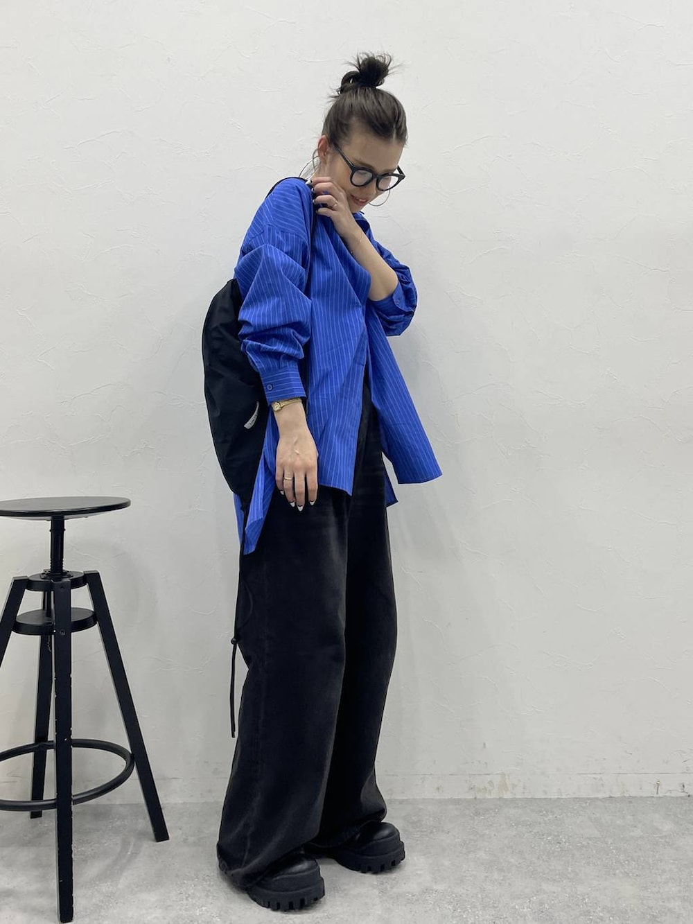 グレー系のデニムパンツ、ブラック系のブーツ、ブラック系のバックパック/リュックを着用したレディースの冬コーディネートの3枚目の写真