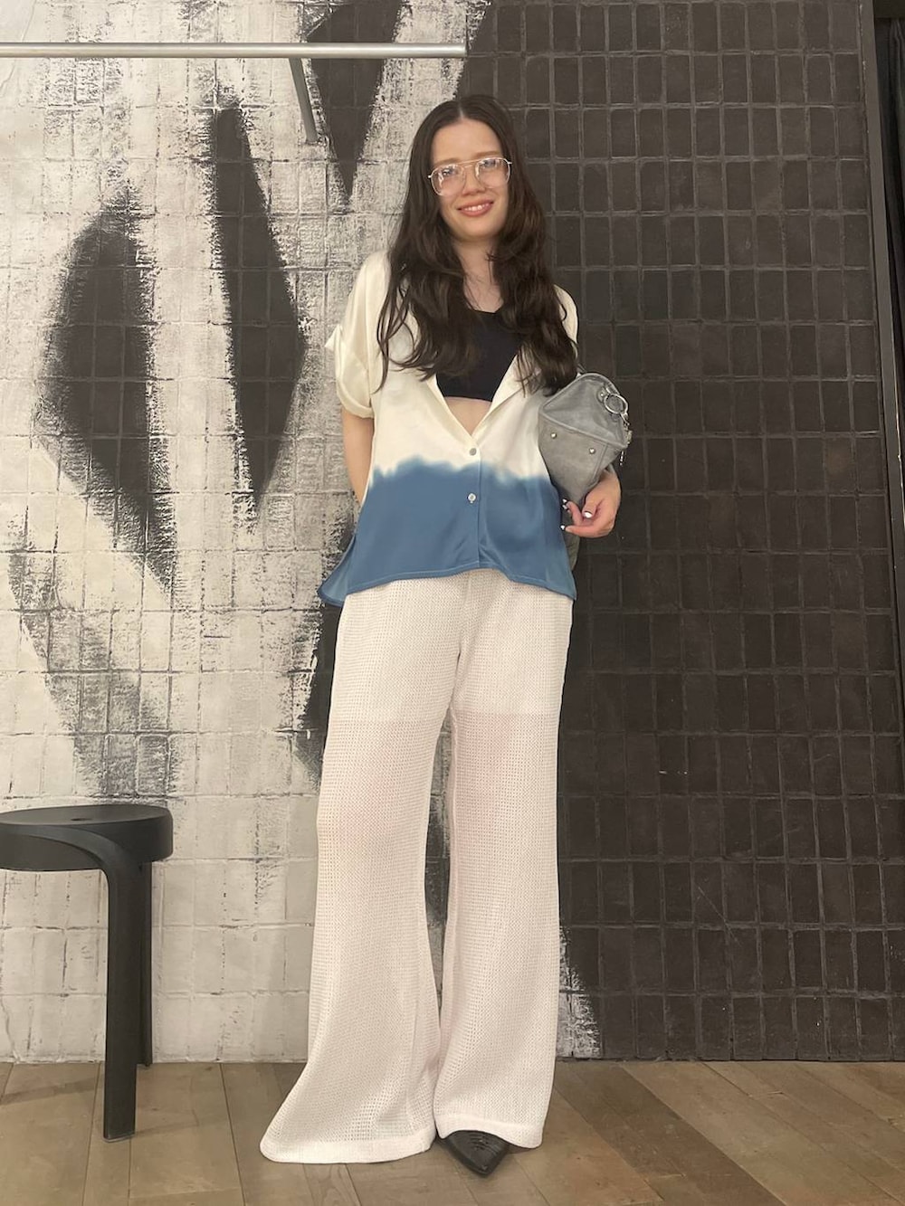 ブルー系のボストンバッグ、ブラック系のパンプス、ホワイト系のその他パンツを着用したレディースの春コーディネートの4枚目の写真