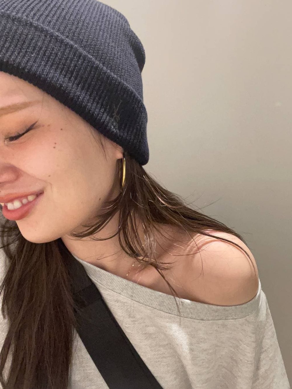 グレー系のスウェット、ブラック系のトートバッグ、ブラック系のデニムパンツを着用したレディースの冬コーディネートの2枚目の写真