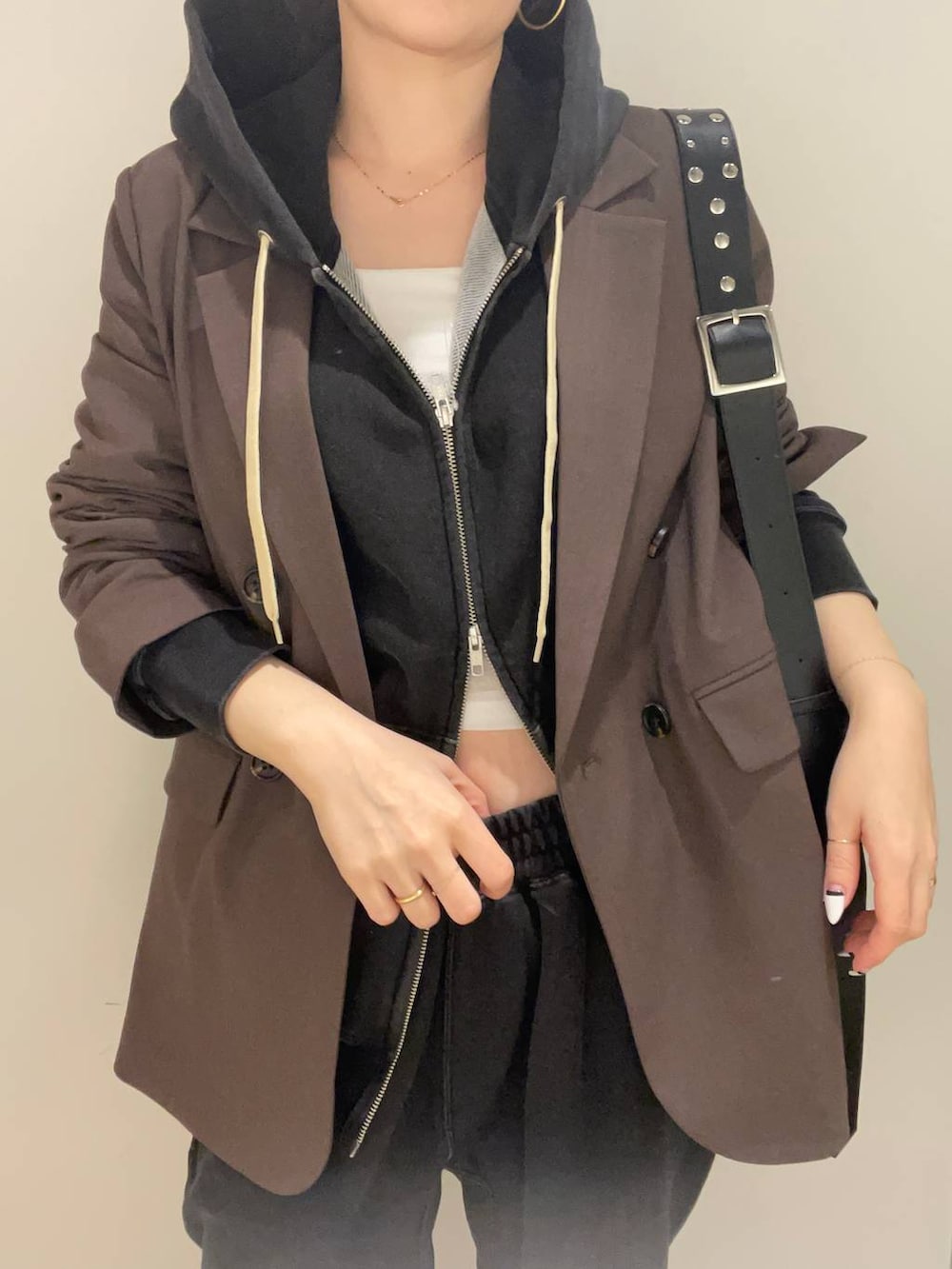 ブラック系のパーカー、ブラック系のスウェットパンツ、ホワイト系のキャミソールを着用したレディースの冬コーディネートの6枚目の写真