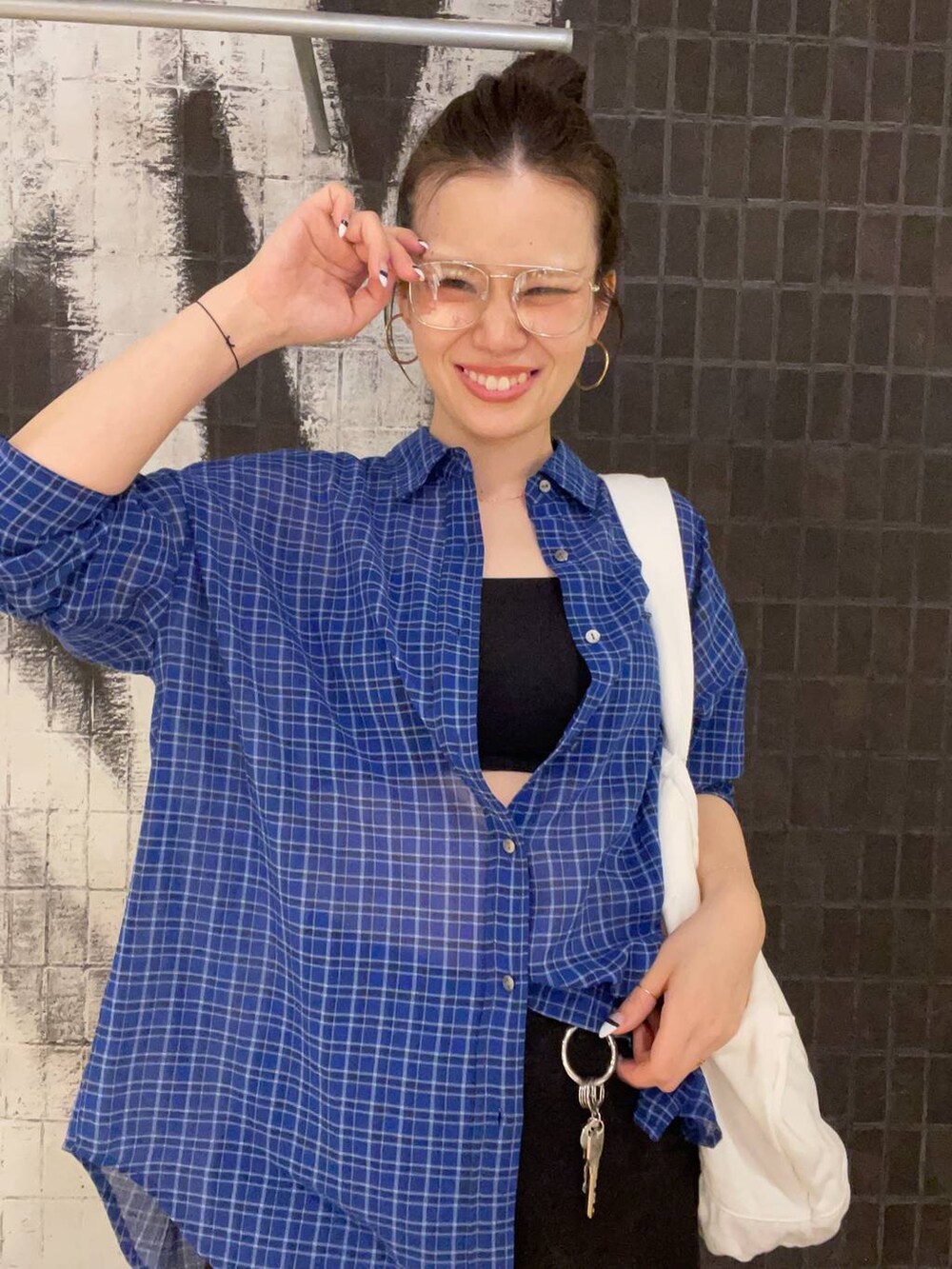 ブラック系のデニムパンツ、ブラック系のサンダル、ブルー系のシャツ/ブラウスを着用したレディースの春コーディネートの4枚目の写真